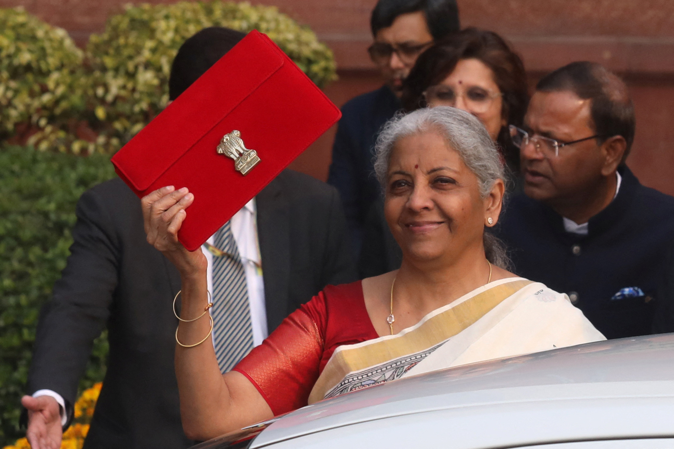 India's Finance Minister Nirmala Sitharaman holds up a folder with the Government of India's logo as she leaves her office.