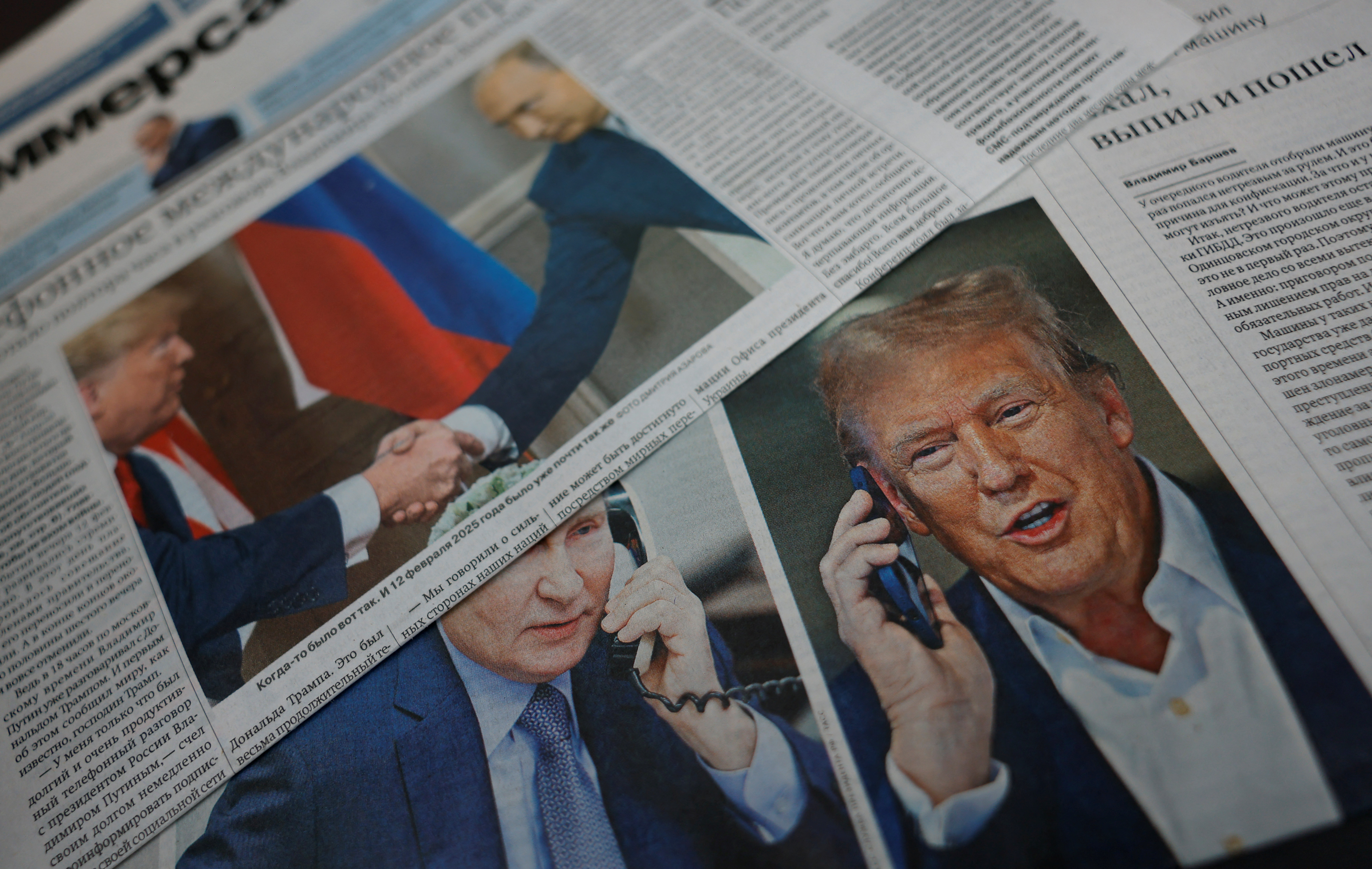 Daily newspapers with covers, dedicated to the recent phone call of President Vladimir Putin and US President Donald Trump, are laid out at a newsstand in a street.