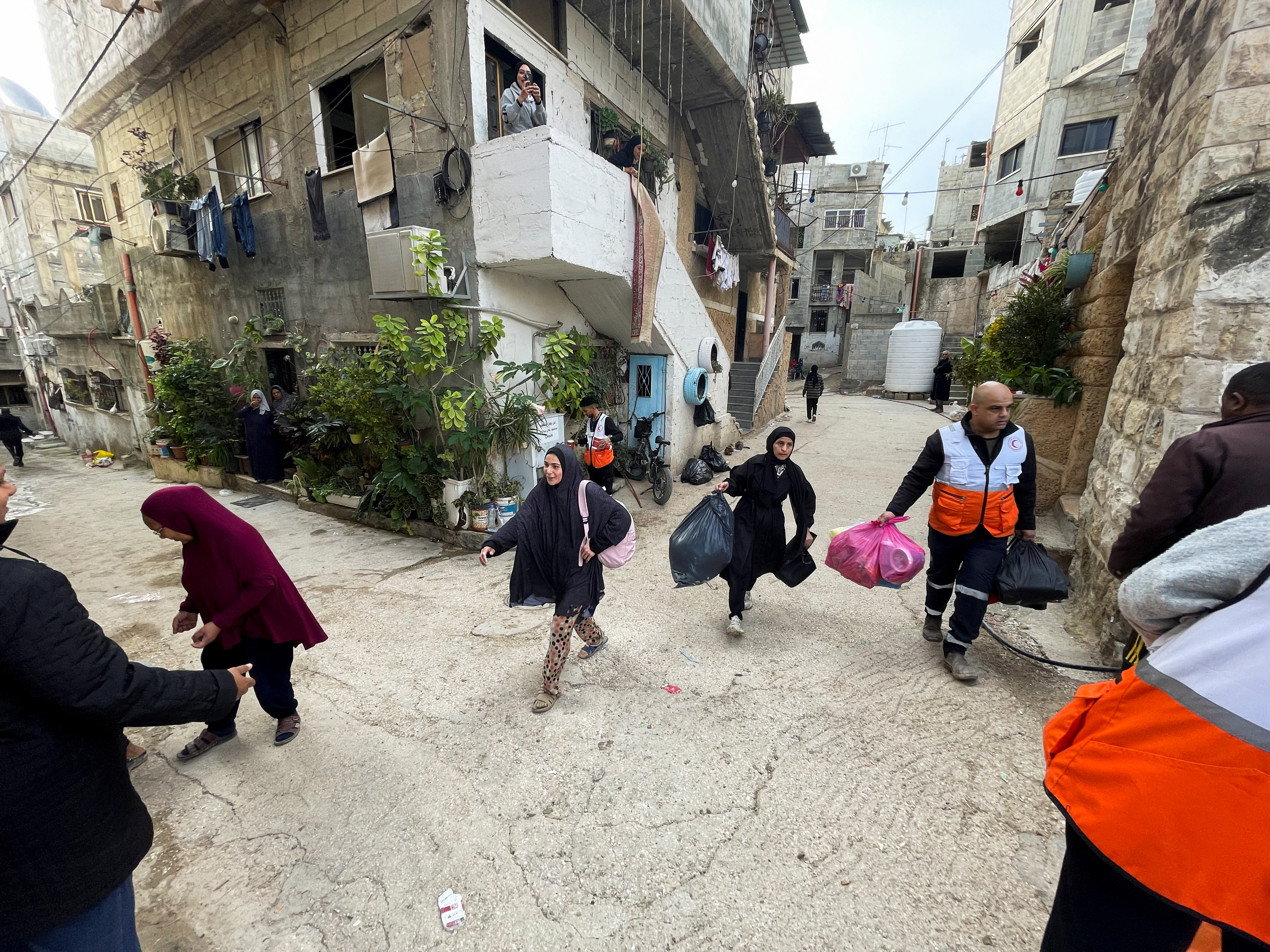 Palestinians flee with their belongings as the Israeli military raids Tulkarem refugee camp.