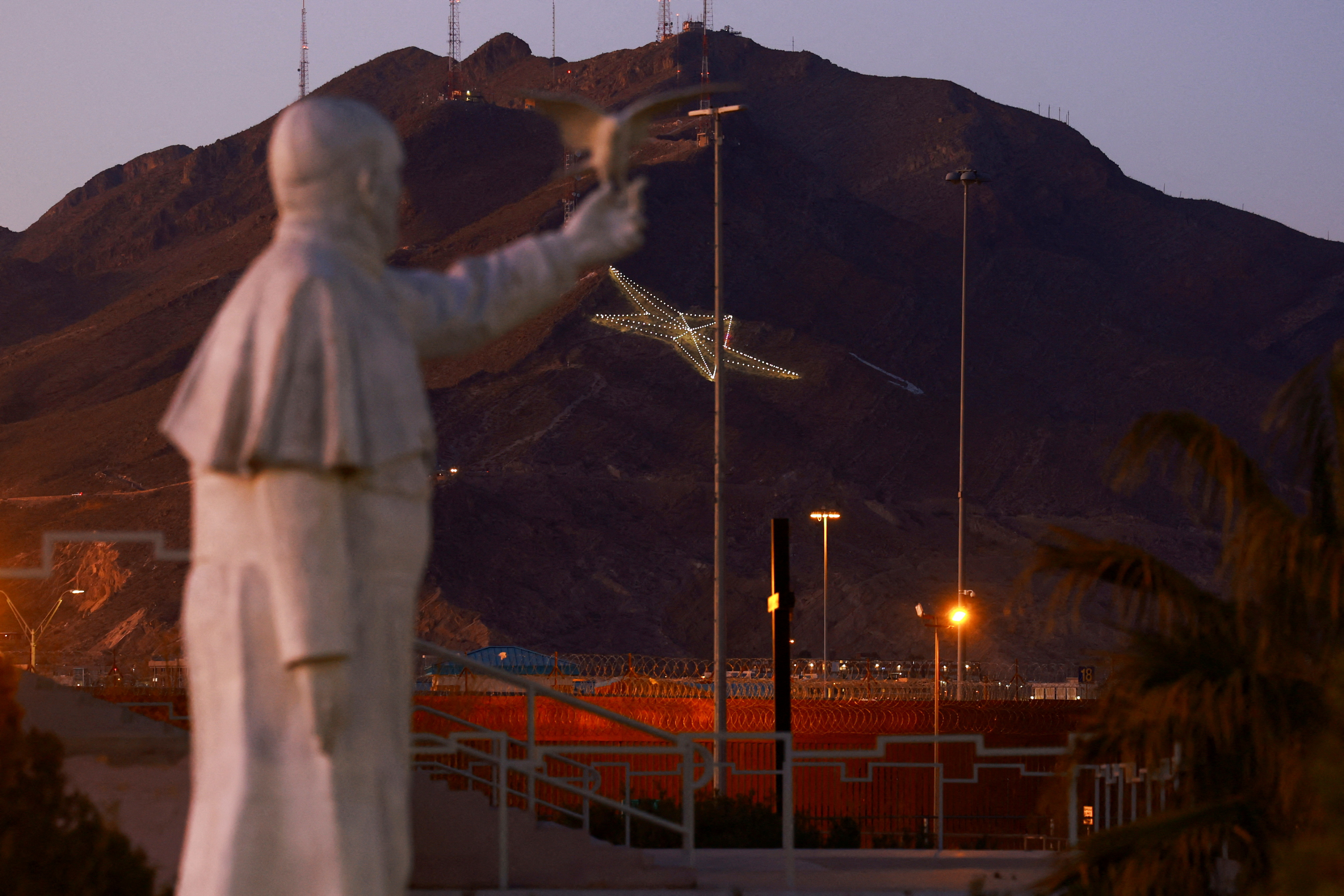 The border wall is seen near a statue of Pope Francis at the site where he celebrated mass in 2016 on the border between Mexico and the United States, in Ciudad Juarez, Mexico, February 22, 2025. REUTERS/Jose Luis Gonzalez TPX IMAGES OF THE DAY