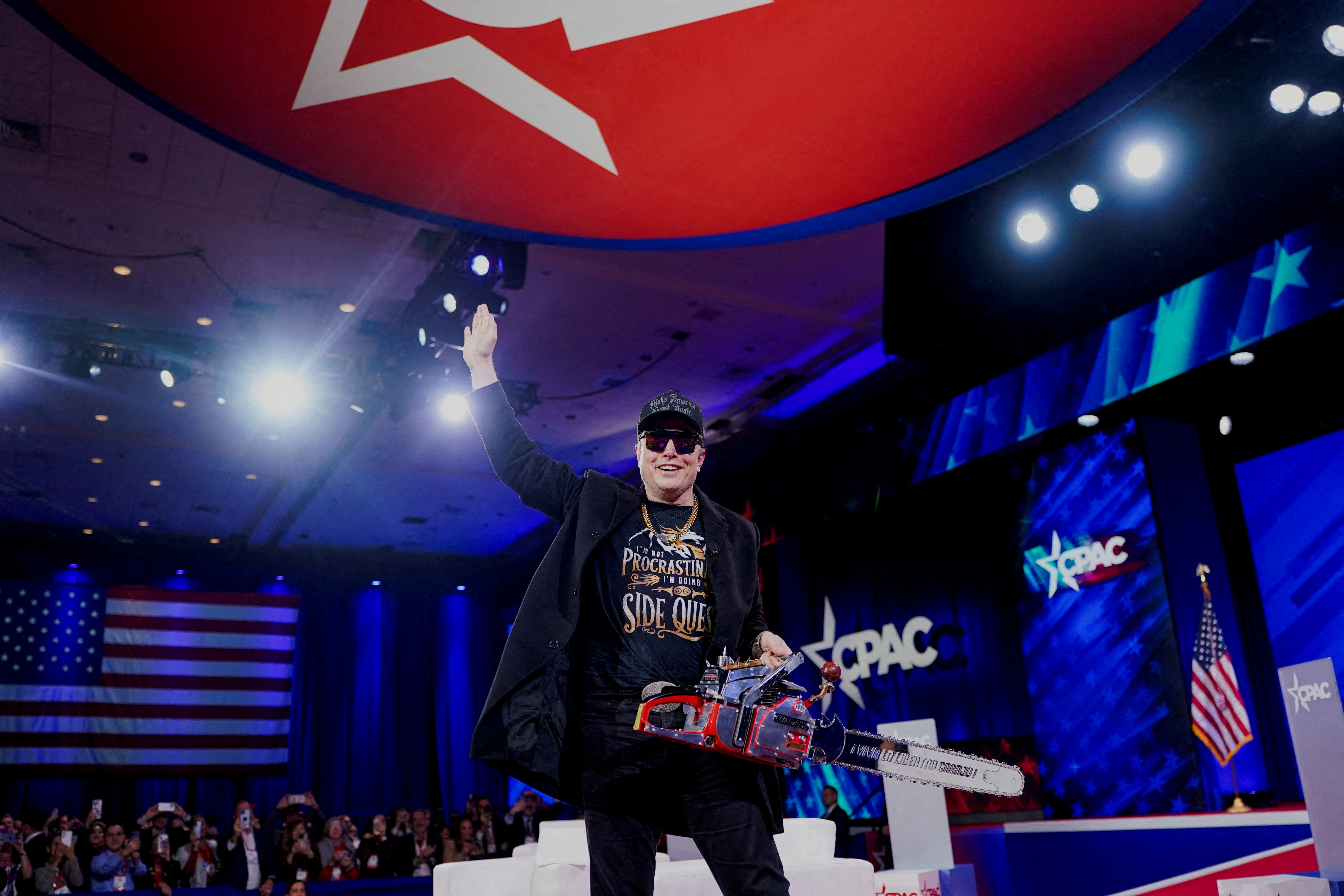Elon Musk holds a chainsaw onstage as he attends the Conservative Political Action Conference (CPAC) in National Harbor, Maryland, on February 20, 2025. [Nathan Howard/Reuters]