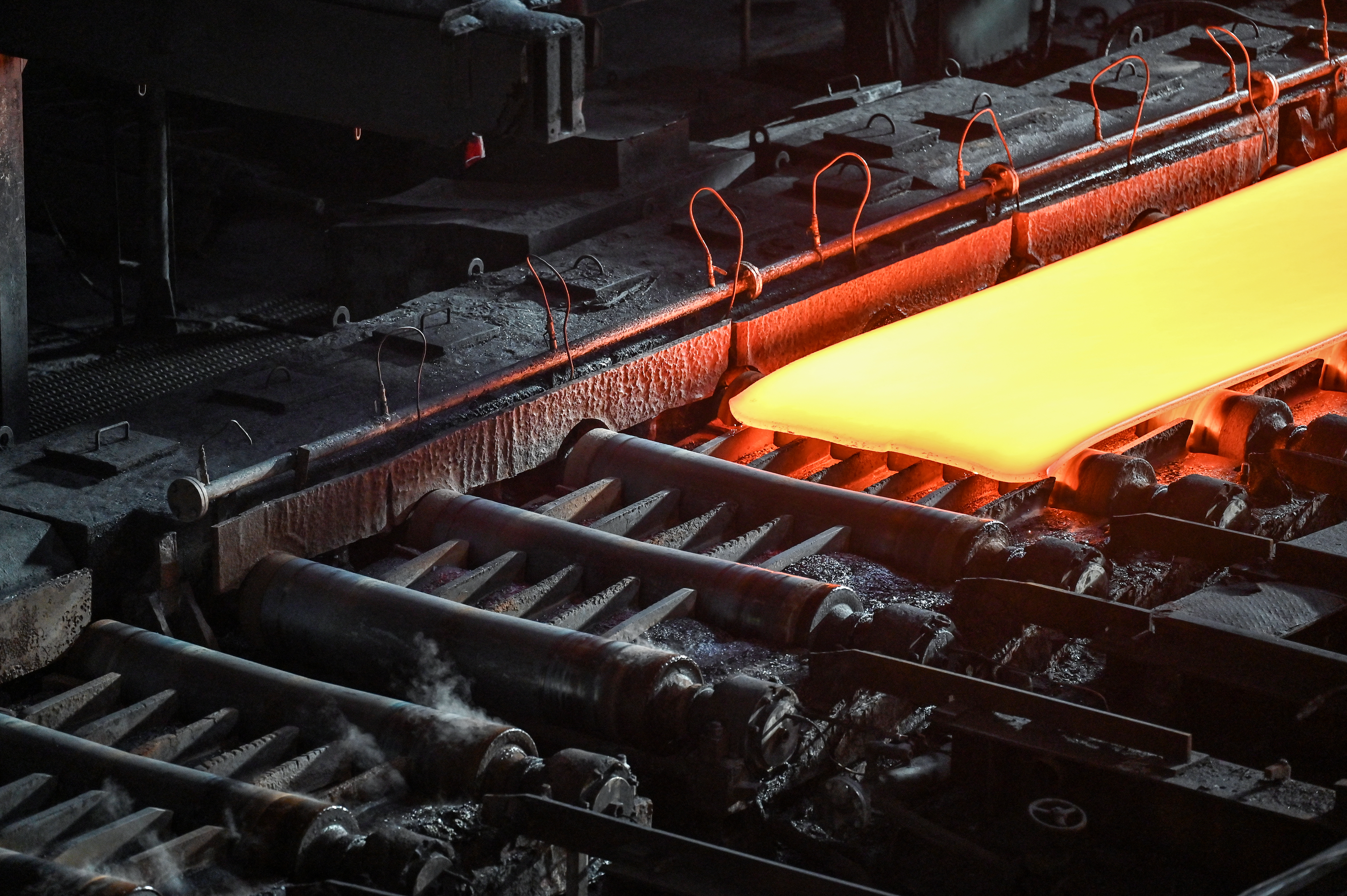 Steel moving along rollers at a hot rolling mill.