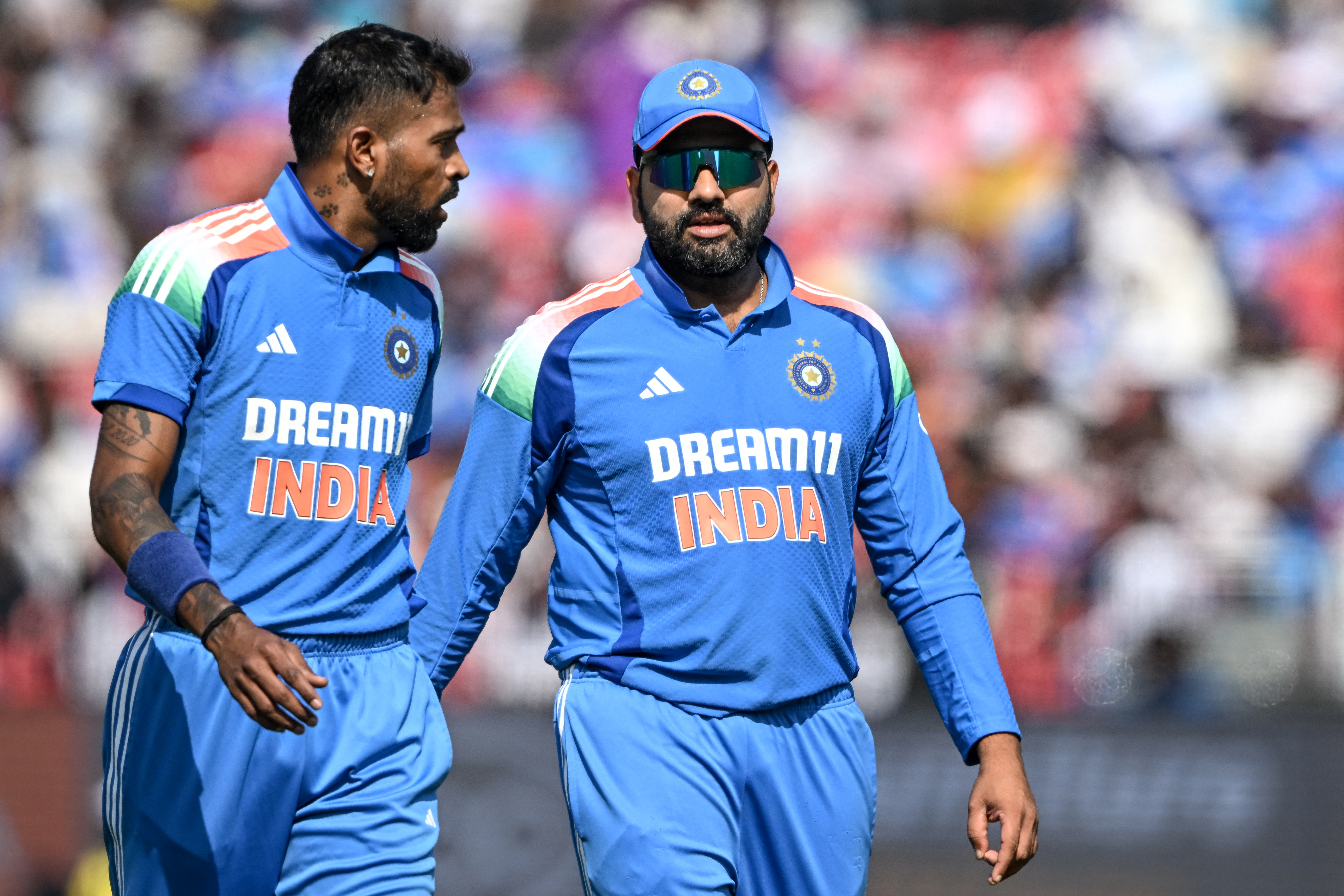 India's captain Rohit Sharma (R) speaks with his teammate Hardik Pandya during the second one-day international (ODI) cricket match between India and England at the Barabati Stadium in Cuttack on February 9, 2025. (Photo by DIBYANGSHU SARKAR / AFP) / -- IMAGE RESTRICTED TO EDITORIAL USE - STRICTLY NO COMMERCIAL USE --
