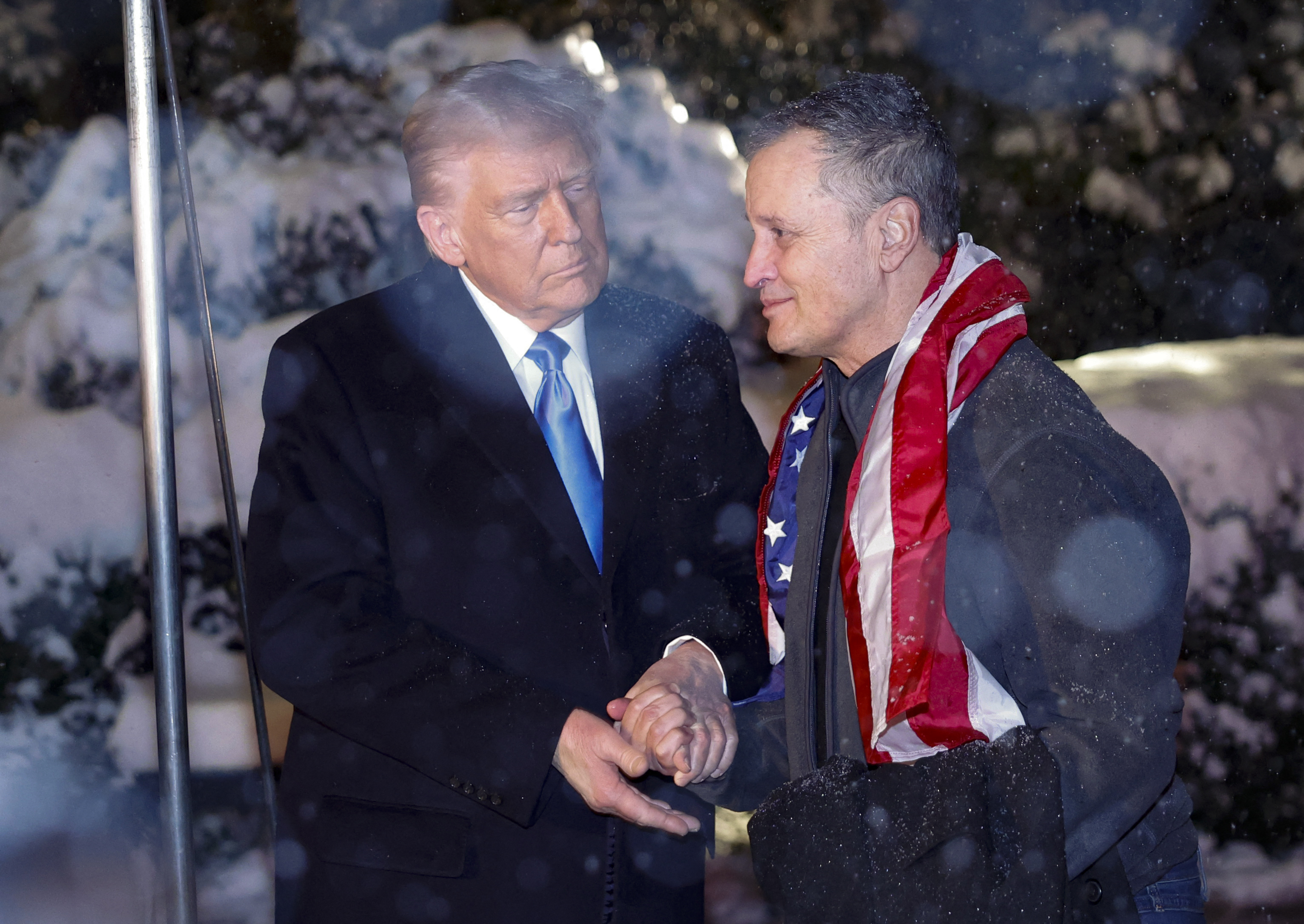 US President Donald Trump greets former detainee Marc Fogel as he arrives at the White House under heavy snowfall in Washington, DC, on February 11, 2025. Fogel, a US teacher detained in Russia since 2021 on drugs charges, was released February 11 after an "exchange" with Moscow, the White House. Trump said he hoped Fogel's release could mark the start of fresh ties with Moscow to end the Ukraine war. (Photo by Ting Shen / AFP)