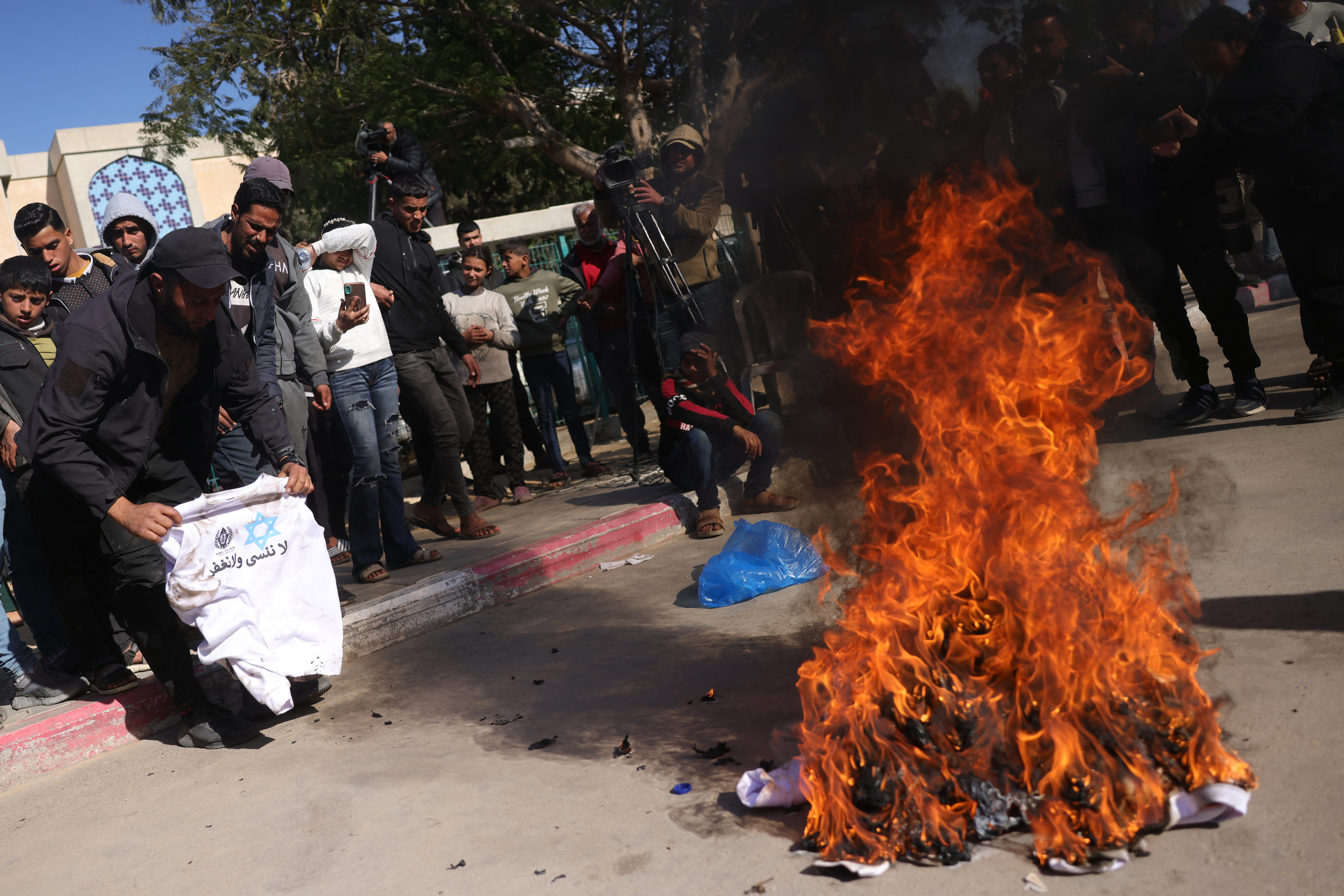 A Palestinian burns a sweatshirt featuring the prison service logo, a Star of David, and the slogan: "We do not forget and we do not forgive", that was given to freed Palestinian prisoners at the European Hospital in Khan Yunis in the southern Gaza Strip