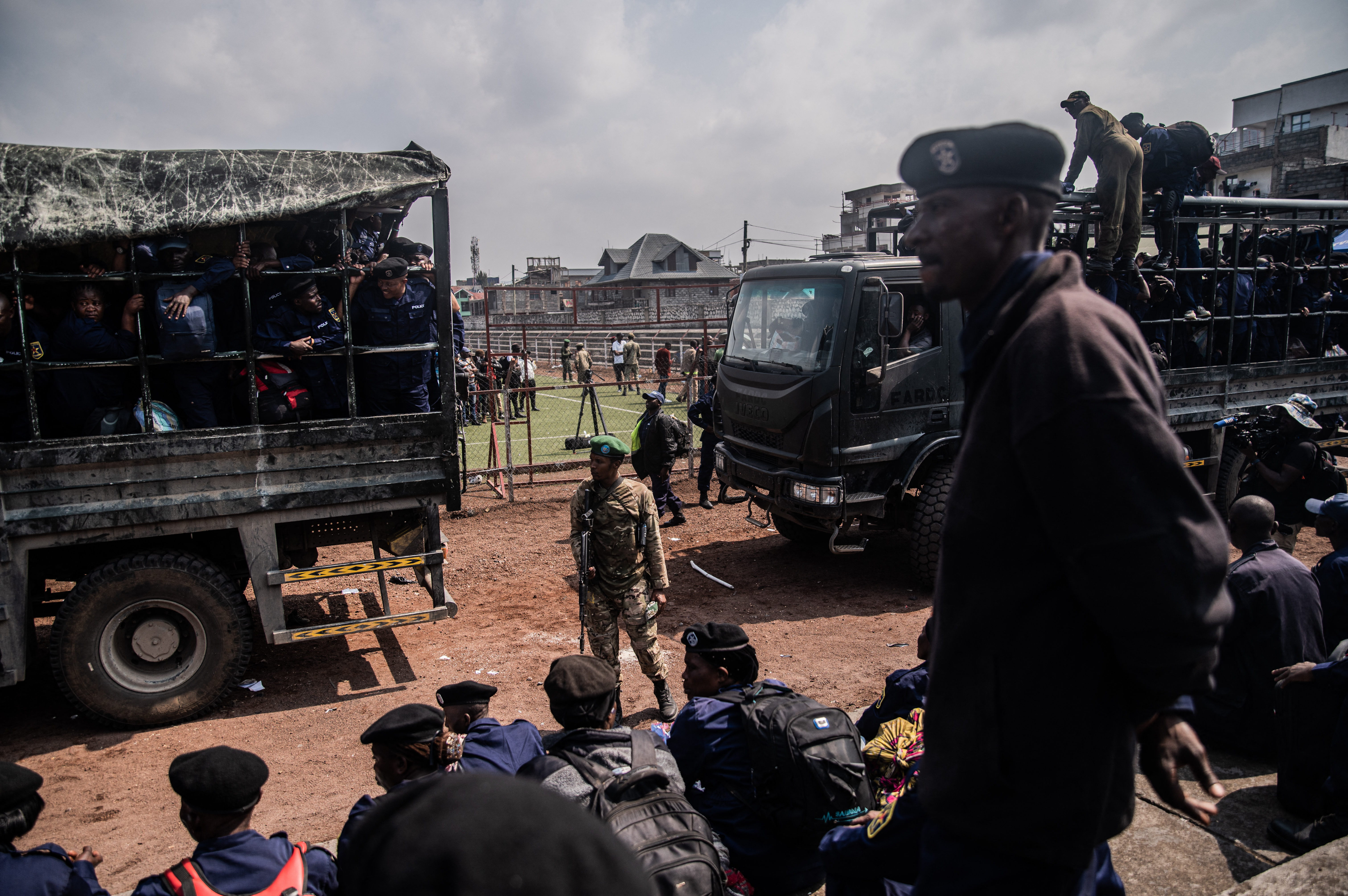 A member of the M23 movement stands guard as Congolese police officers get into a truck.