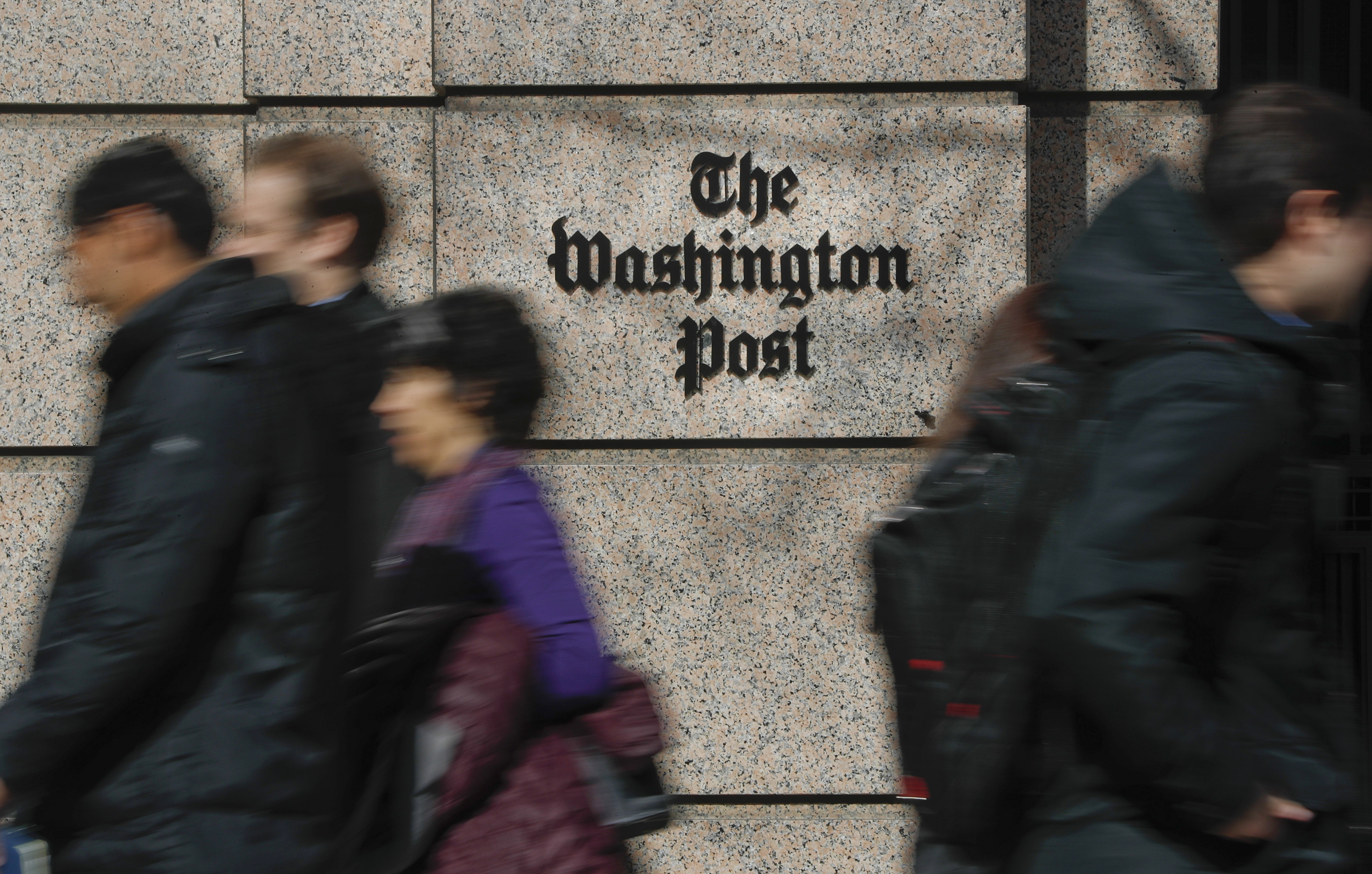 People walk by the One Franklin Square Building, home of The Washington Post newspaper.
