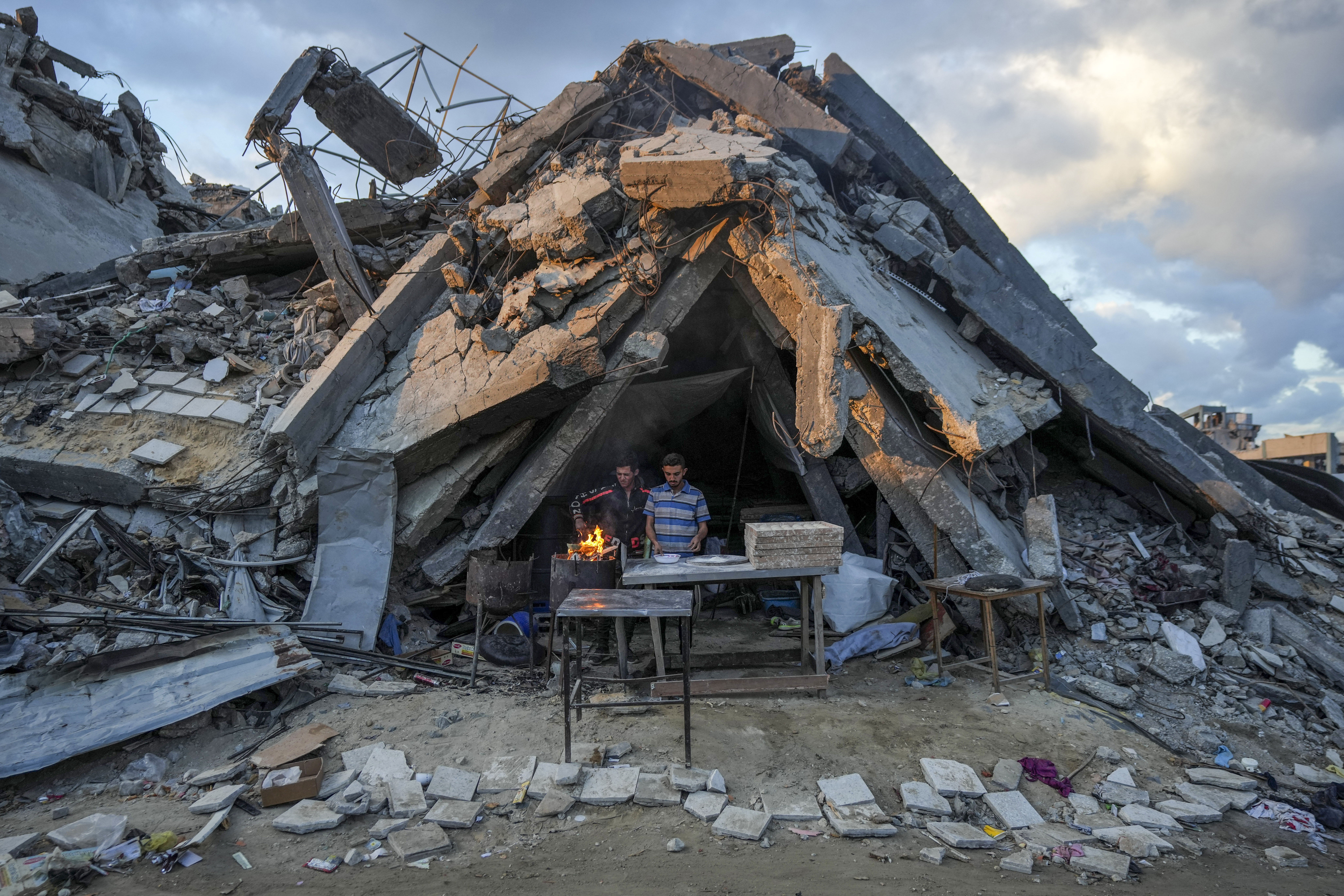 A man sells bread under his bakery destroyed by Israeli attacks in Jabaliya.