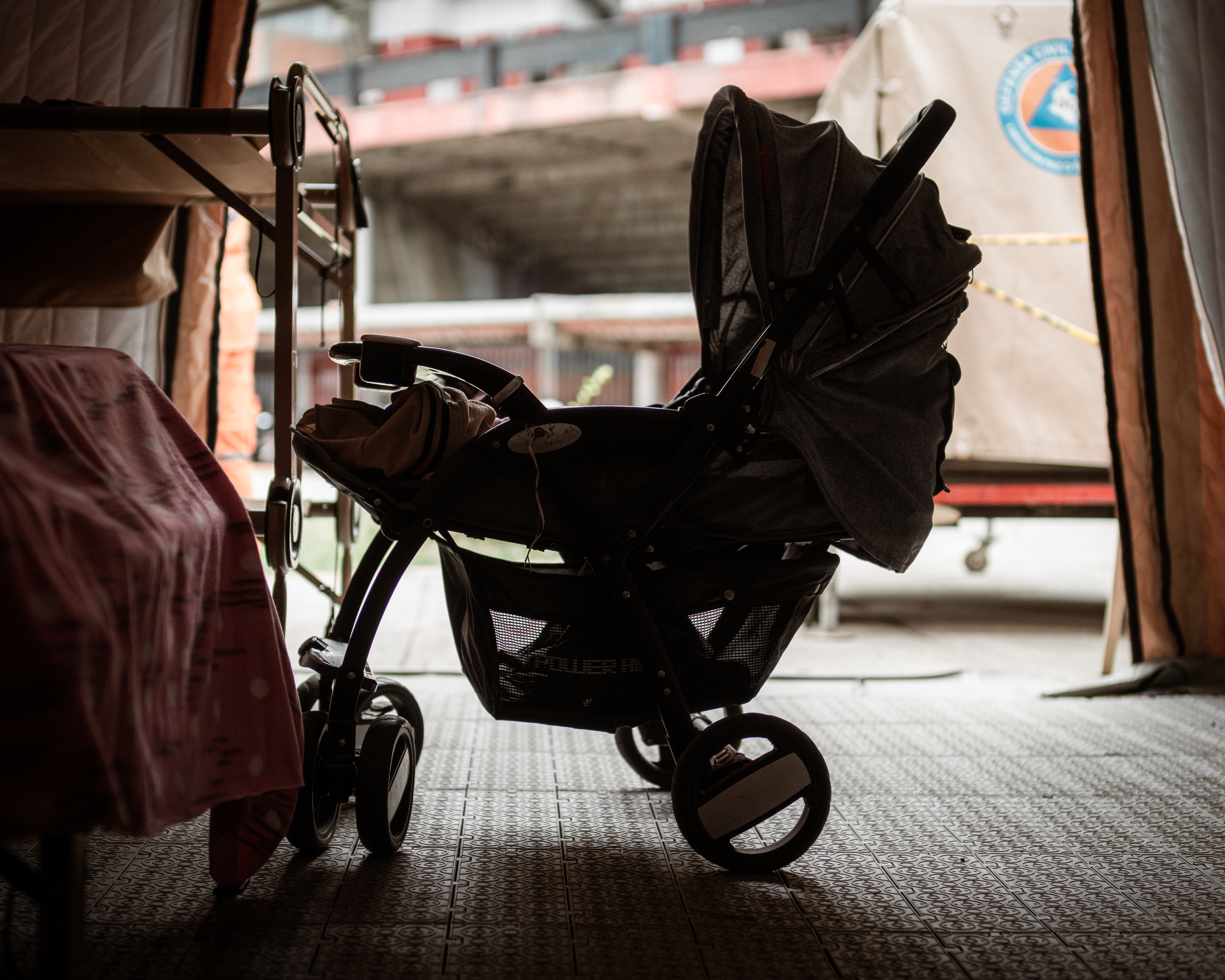 A baby carriage is seen in shadow in a stadium