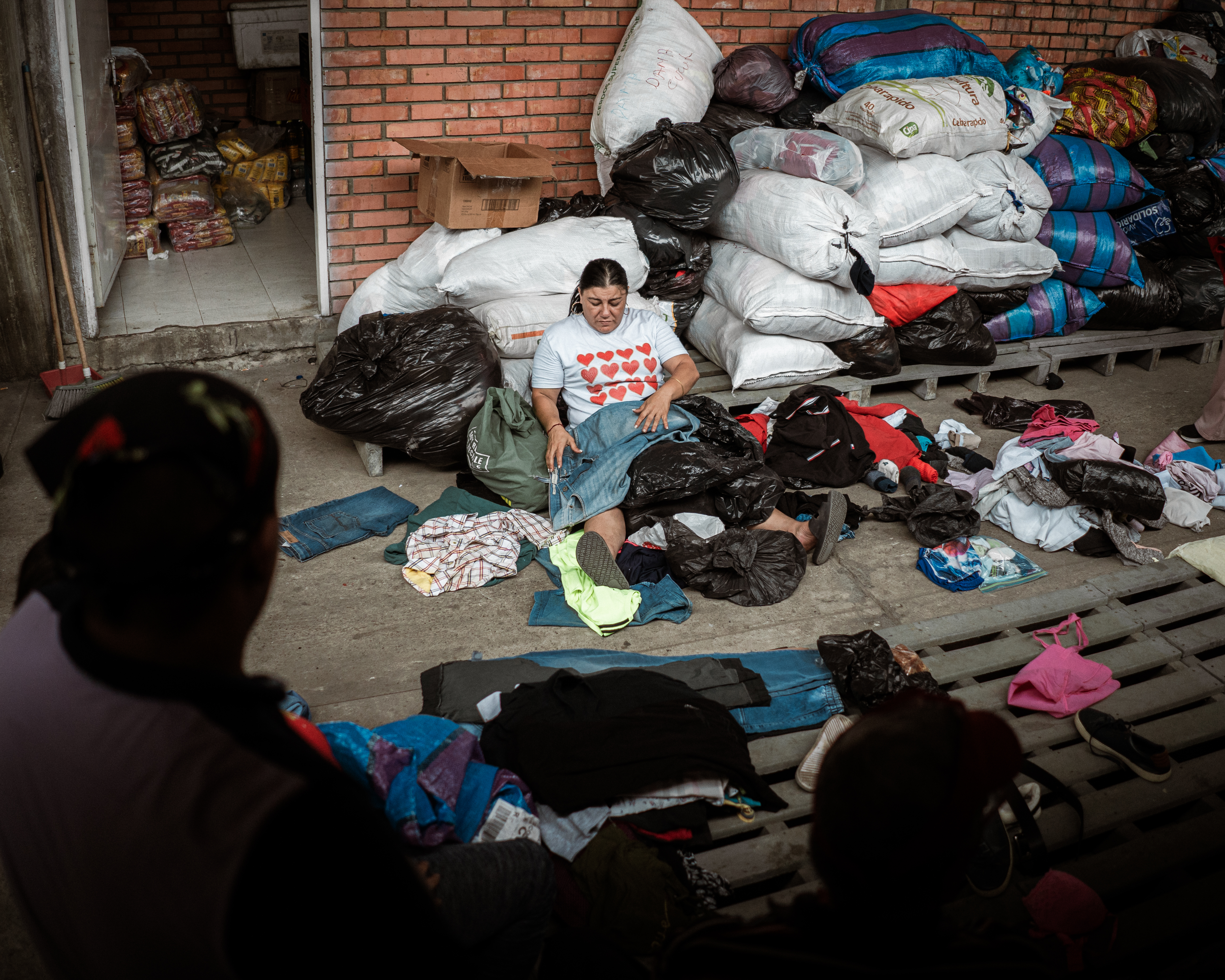 Paula Elorza sits on the floor as she sorts through donated clothes. Bags of clothing have arrived from Bogota, Bucaramanga and the residents of Cúcuta