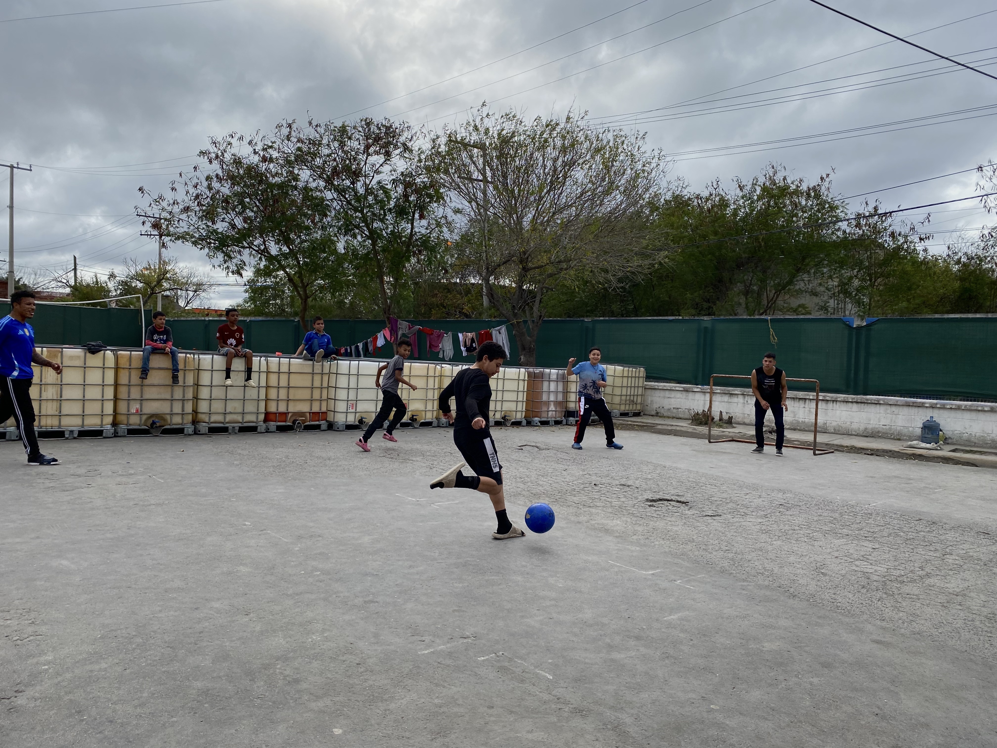 Young boys playing soccer outdoors in Matamoros