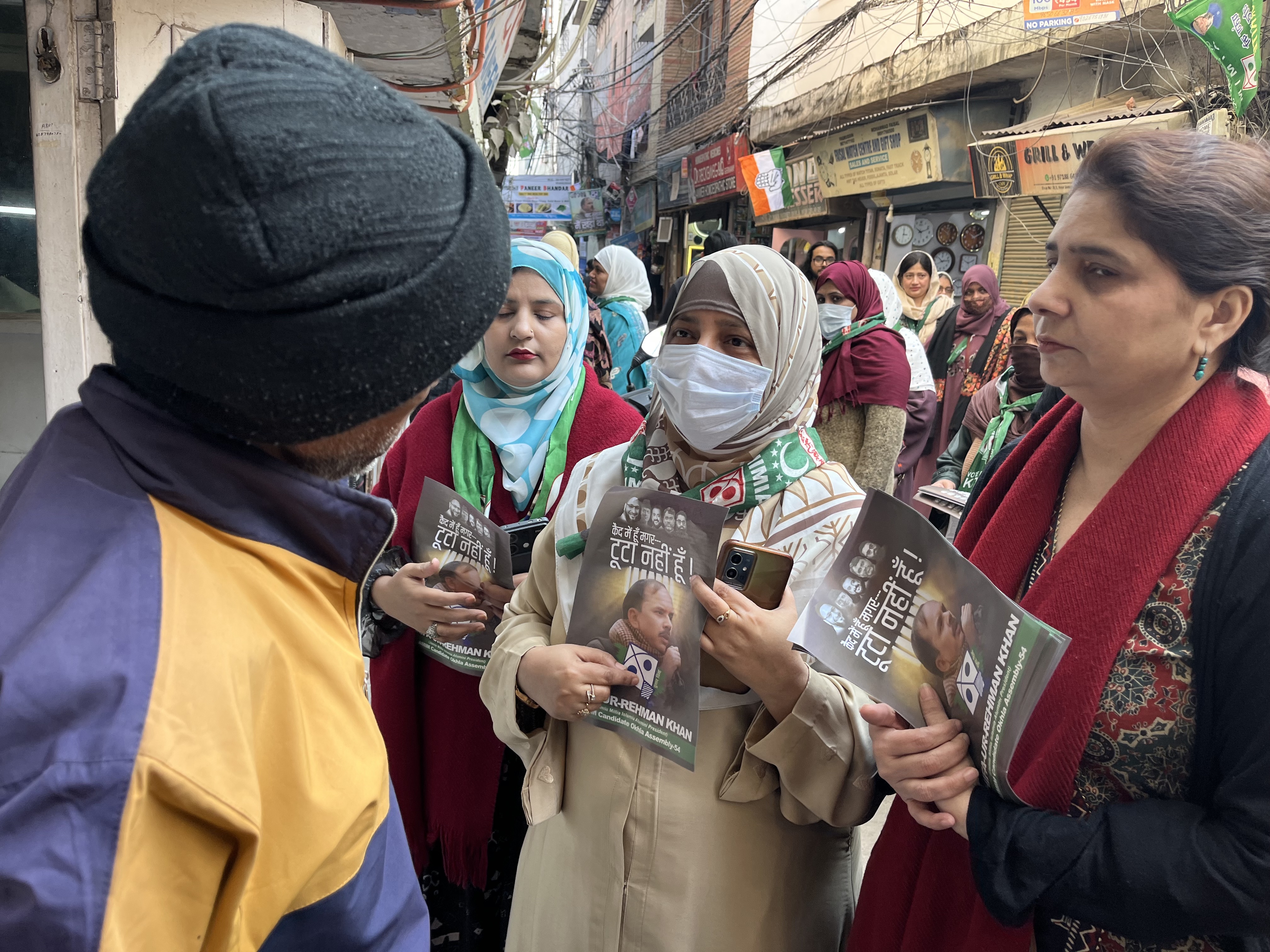 Nooreen Fatima (with a face mask) campaigns for her husband Shifa ur Rehman, in New Delhi's Okhla constituency [Yashraj Sharma/Al Jazeera]