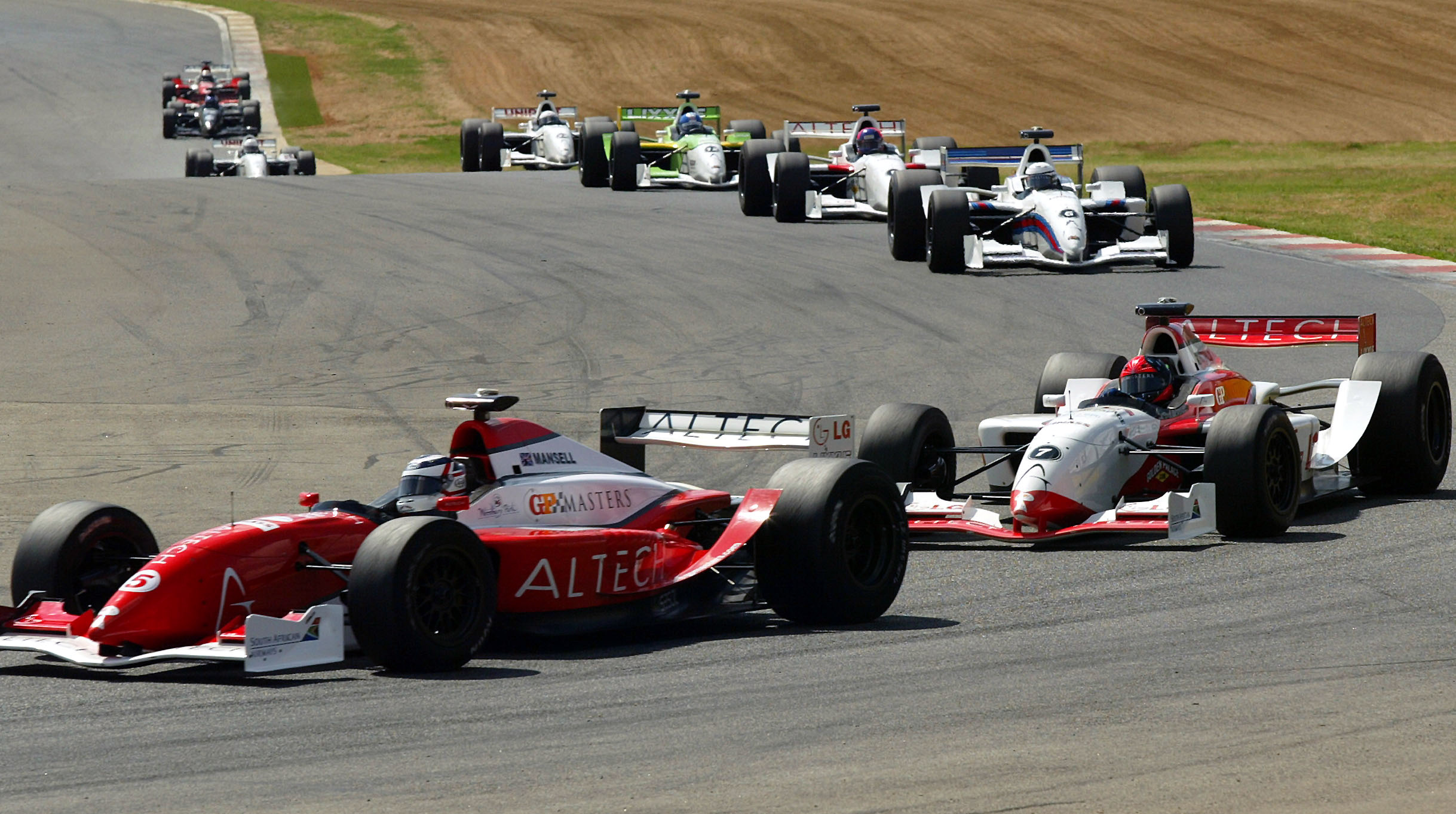 Briton Nigel Mansell (L) leads the race ahead of Brazil's Emerson Fittipaldi during the Grand Prix Masters race at the Kyalami circuit near Johannesburg November 13, 2005. Mansell, 52, led the 30-lap race from start to finish and held off the challenge of Fittipaldi to win by less than half-a-second. REUTERS/Juda Ngwenya