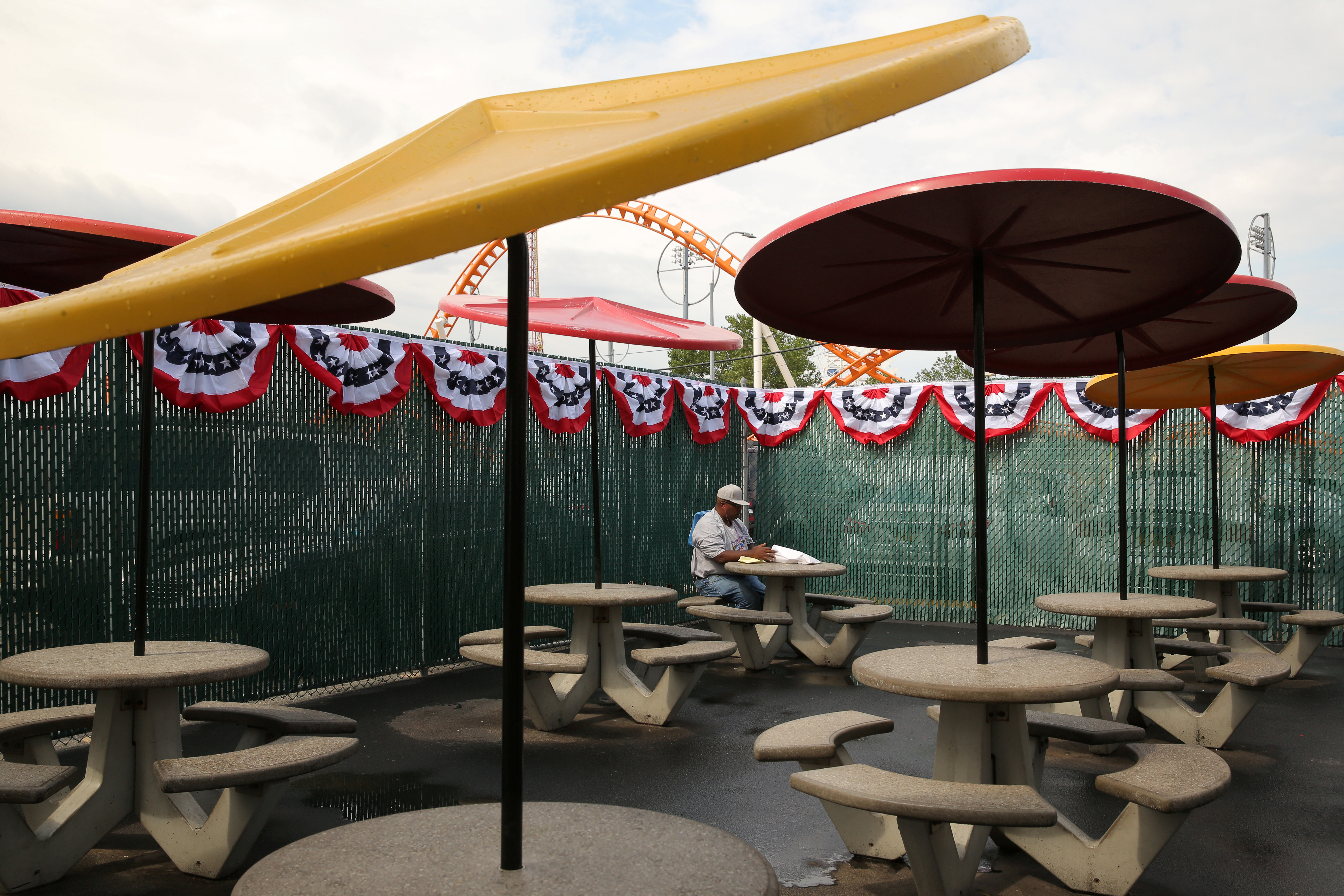 A man eats alone in a food court at New York City's Coney Island on July 4, 2017. REUTERS/Andrew Kelly