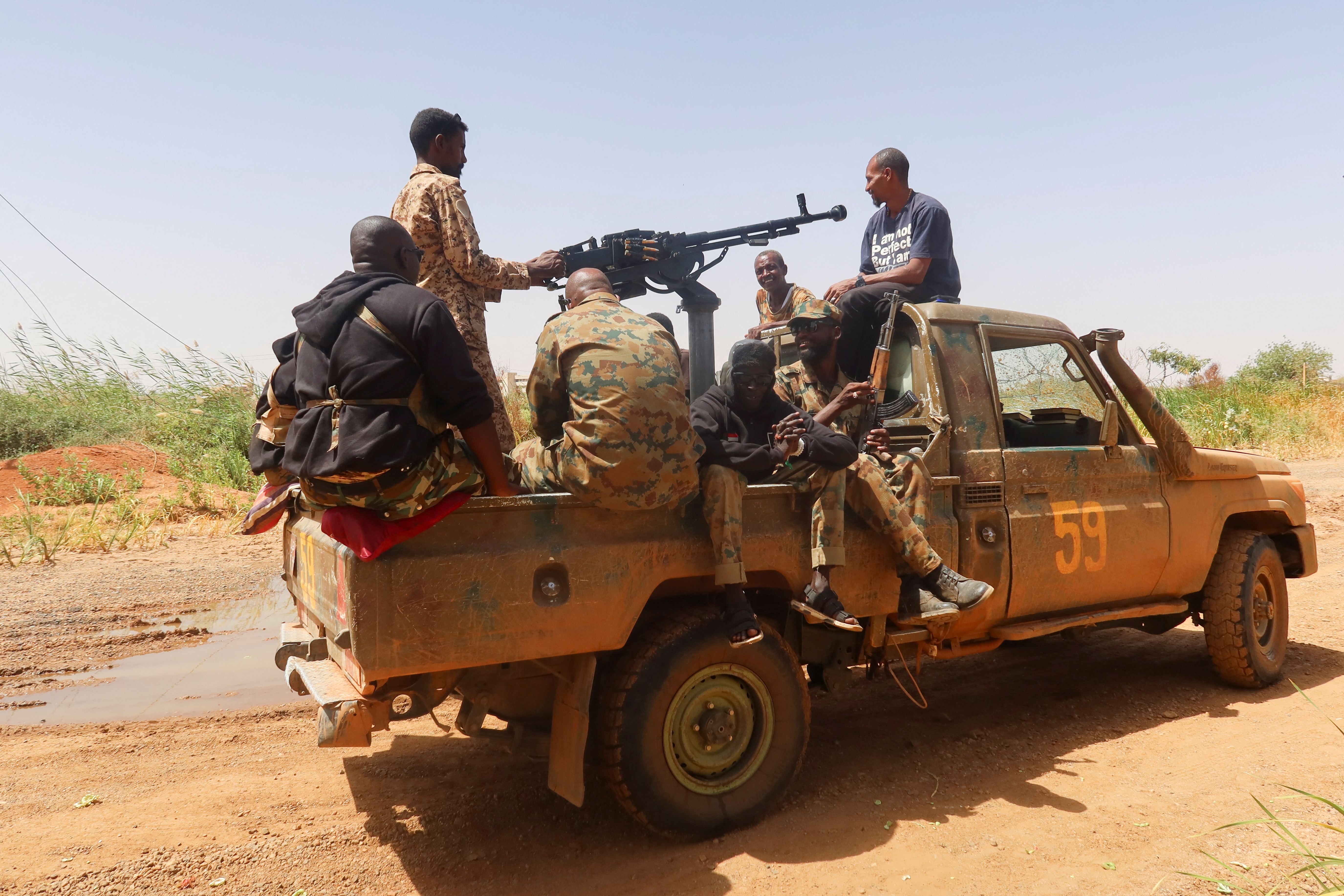 Members of Sudanese armed forces sit on an army vehicle in Omdurman, Sudan