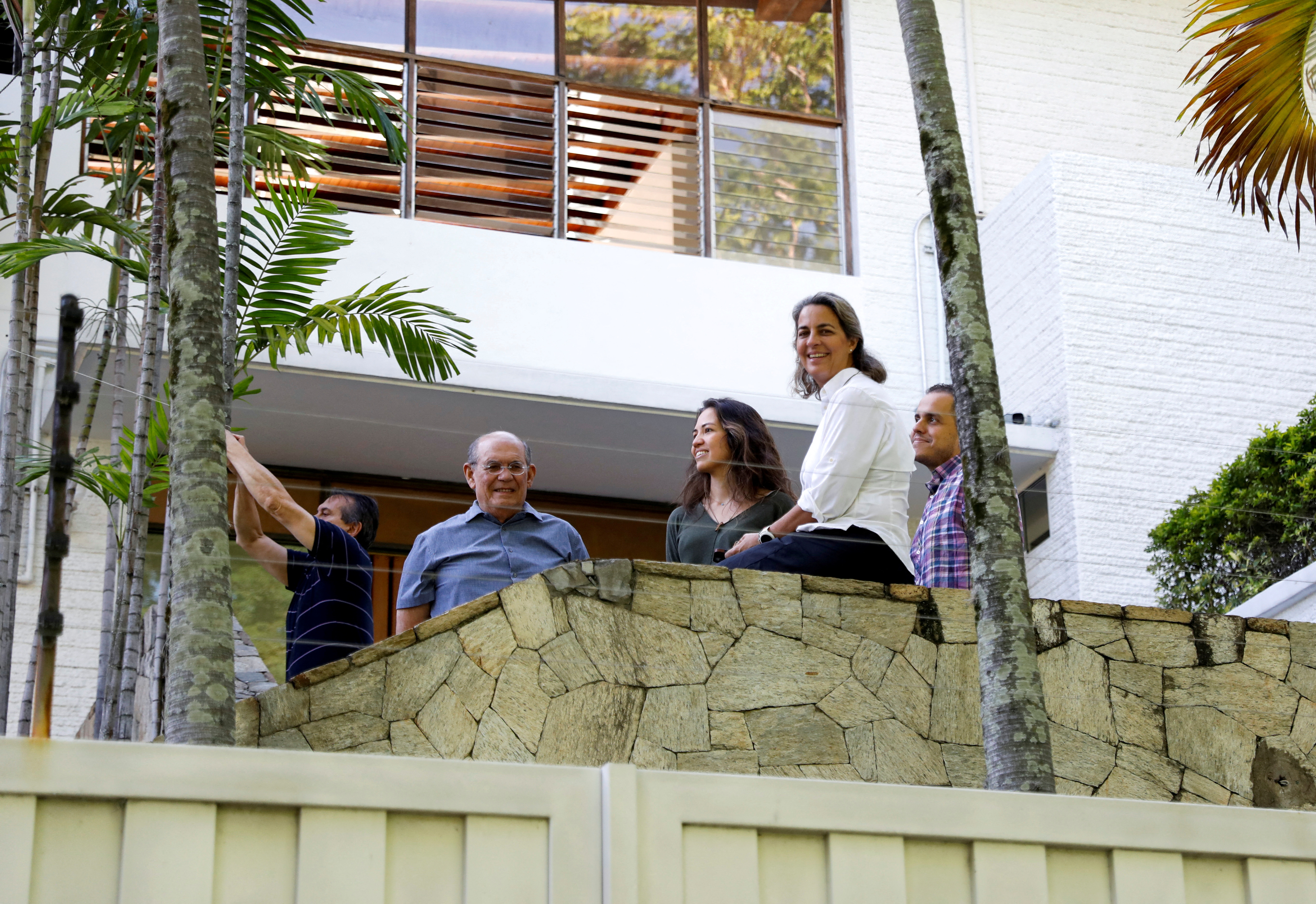 Venezuelan opposition members Humberto Villalobos, Omar Gonzalez, Claudia Macero, Magalli Meda and Pedro Urruchurtu sit on a balcony at the Argentine embassy.