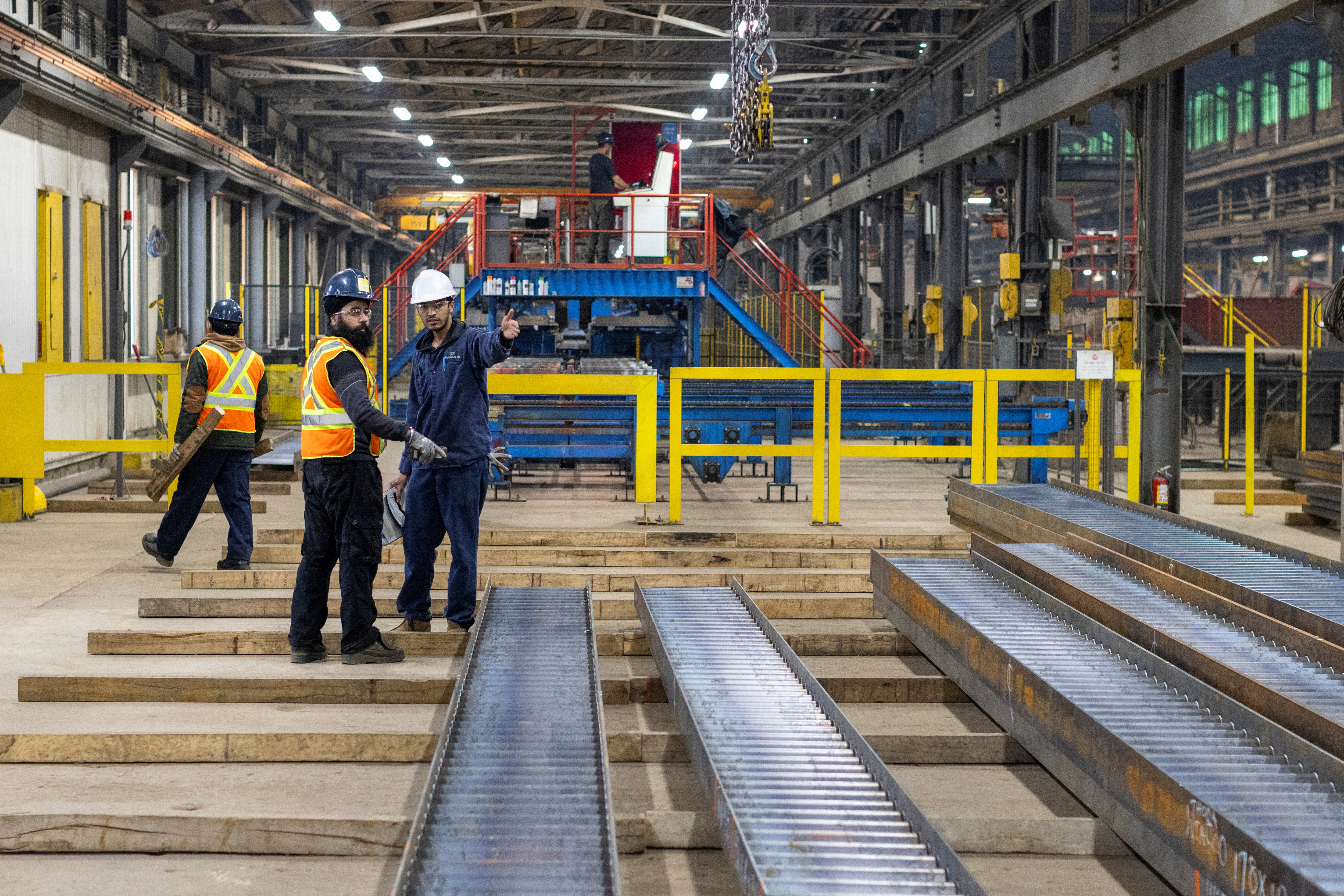Workers discuss their job at a steel design and fabrication company in Ontario, Canada