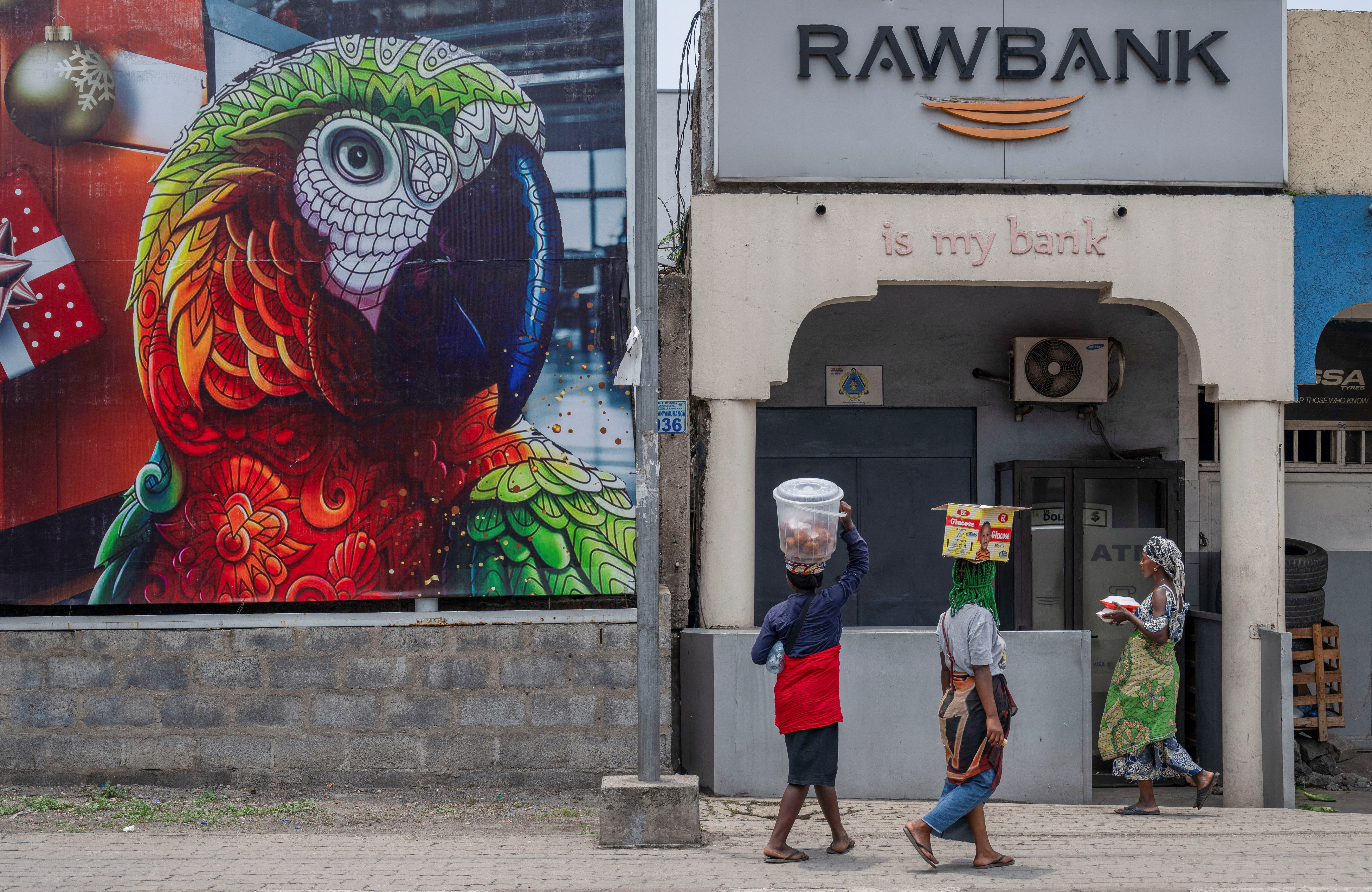 People walk outside the closed Rawbank branch as residents and businesses struggle to access cash and conduct basic transactions