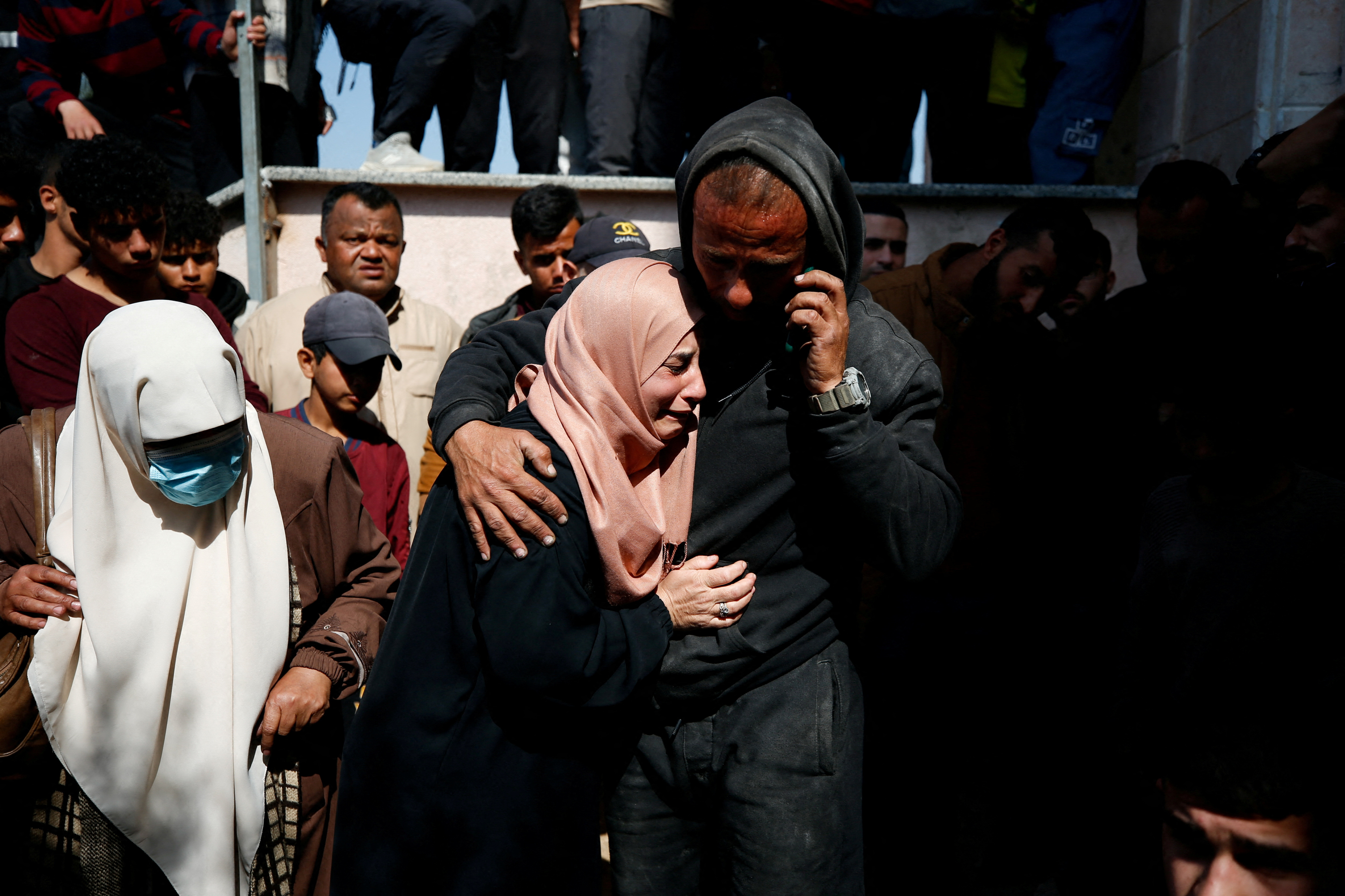 Mourners react next to the bodies of Palestinians killed in an Israeli strike