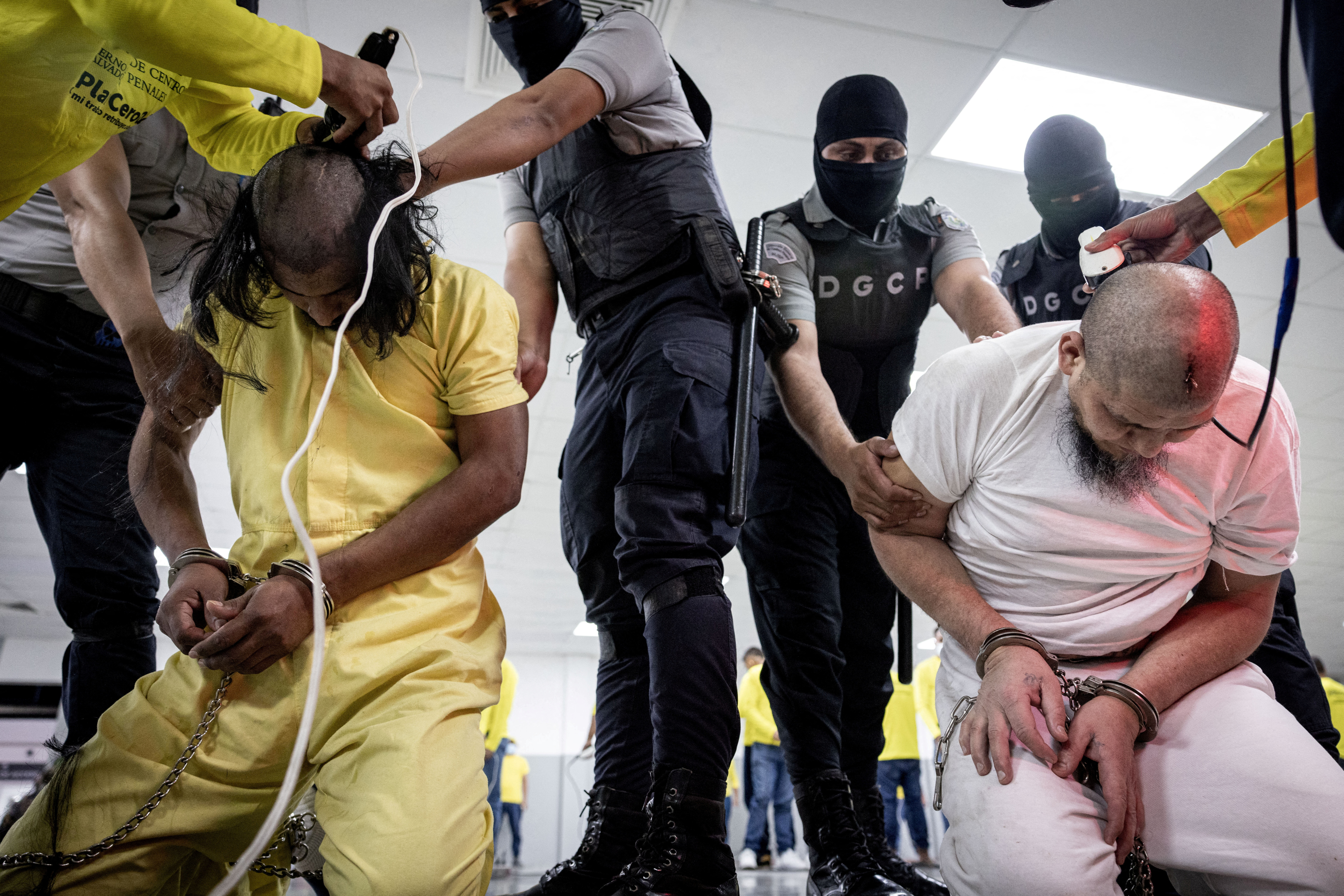Salvadoran police officers cut the hair of alleged members of the Venezuelan gang Tren de Aragua recently deported by the US.
