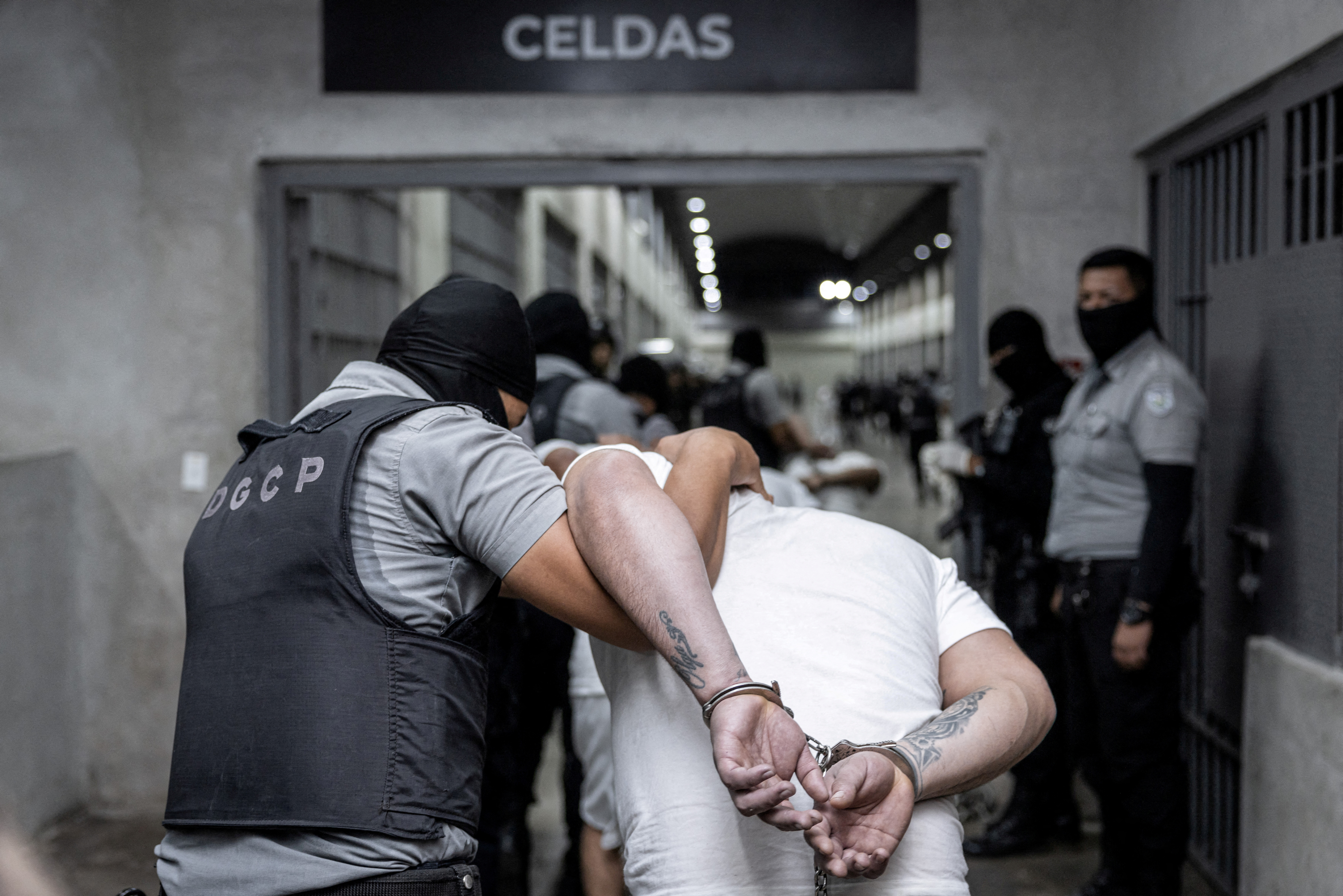 Salvadoran police escort a handcuffed man deported from the United States