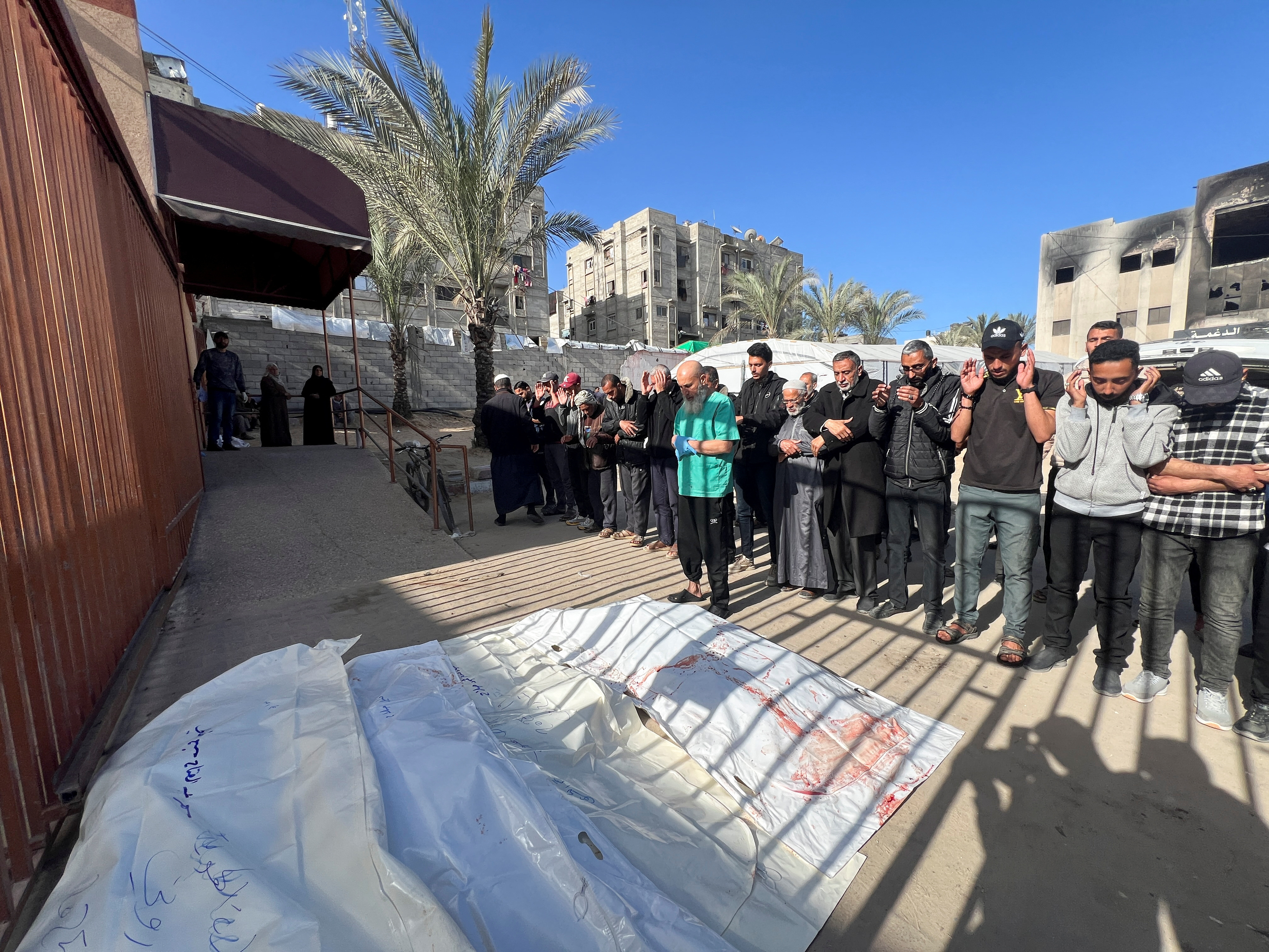 Mourners pray next to the bodies of Palestinians killed in Israeli strikes, at Nasser hosptial in Khan Younis, in the southern Gaza Strip