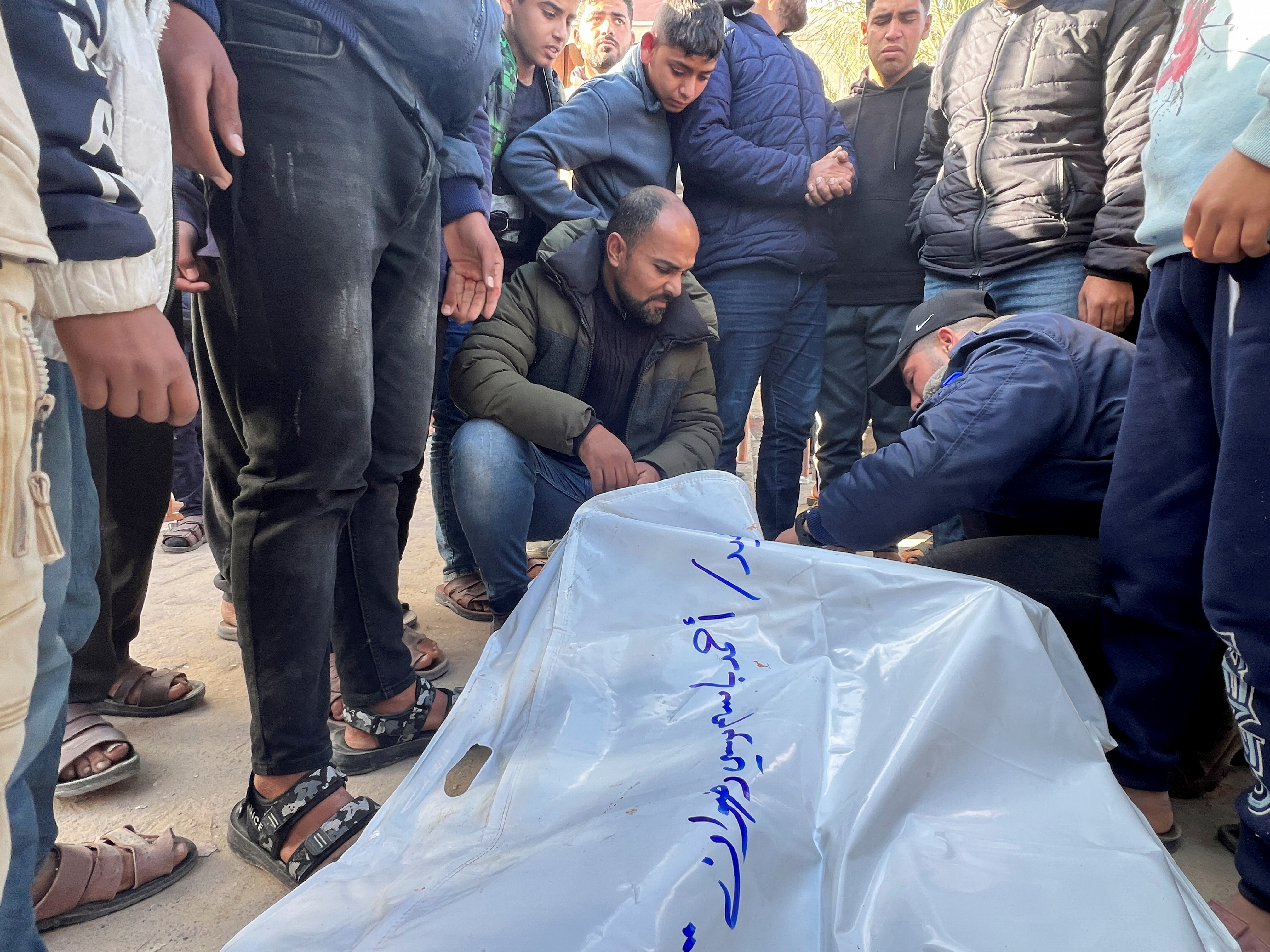 Mourners gather next to the bodies of Palestinians killed in Israeli strikes