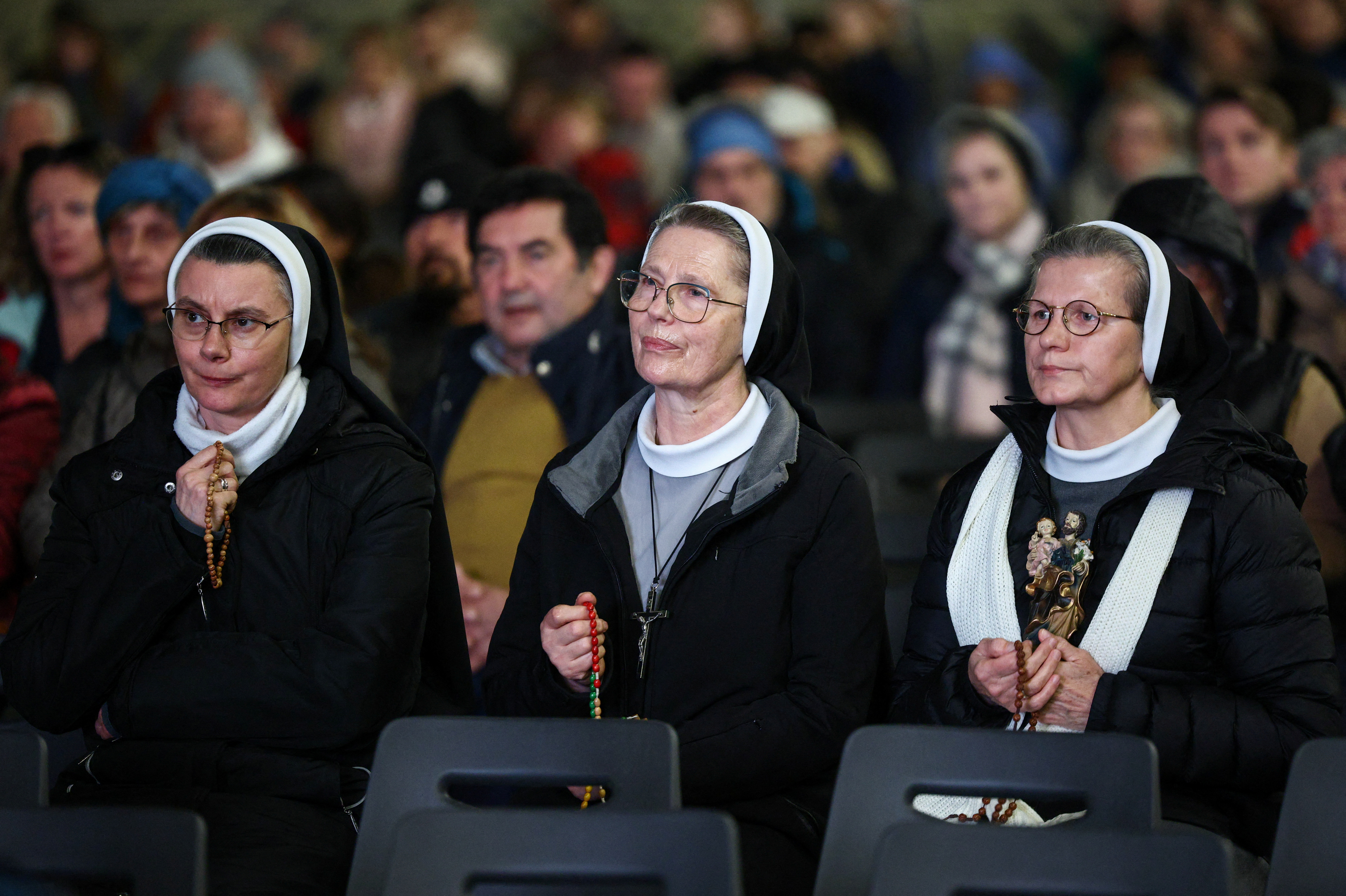 Nuns attend a prayer service in St. Peter's square, as Pope Francis continues hospitalization, at the Vatican