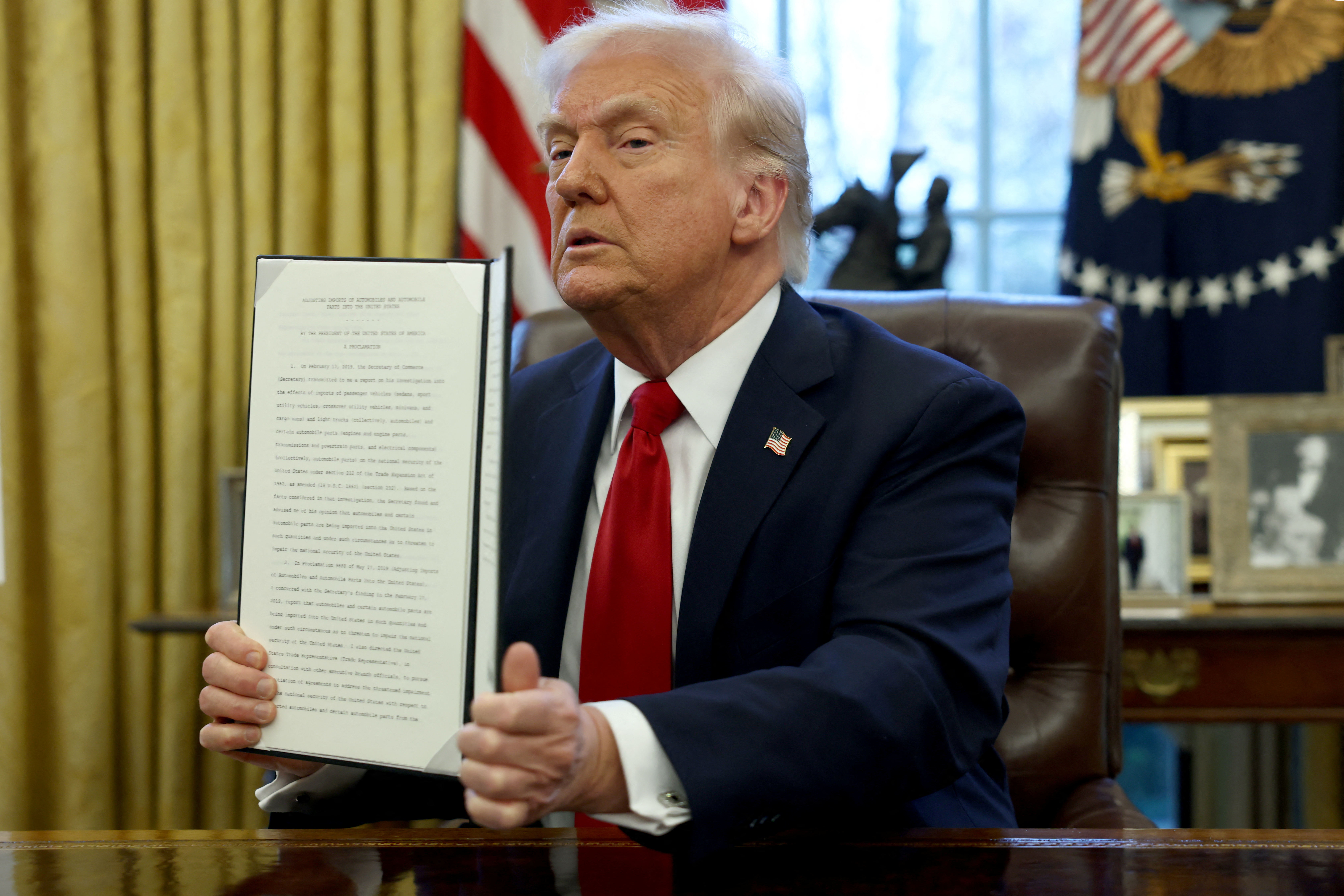 Donald Trump holds up an executive order