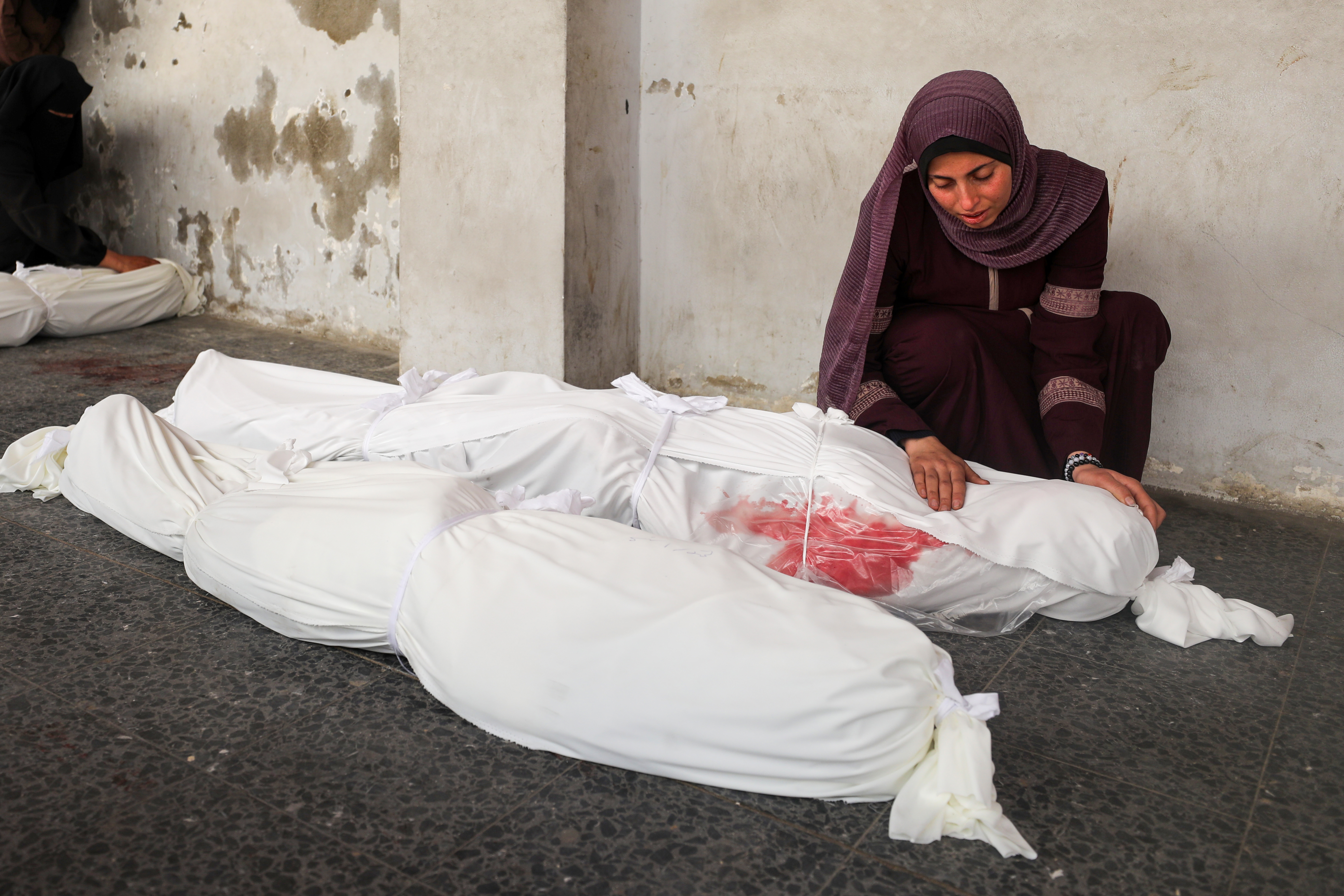 GAZA CITY, GAZA - MARCH 26: Palestinian women mourn by the shrouded bodies of their loved ones, killed in an Israeli attack on Jabalia camp, at Al-Ahli Baptist Hospital in Gaza City, Gaza on March 26, 2025. ( Dawoud Abo Alkas - Anadolu Agency )