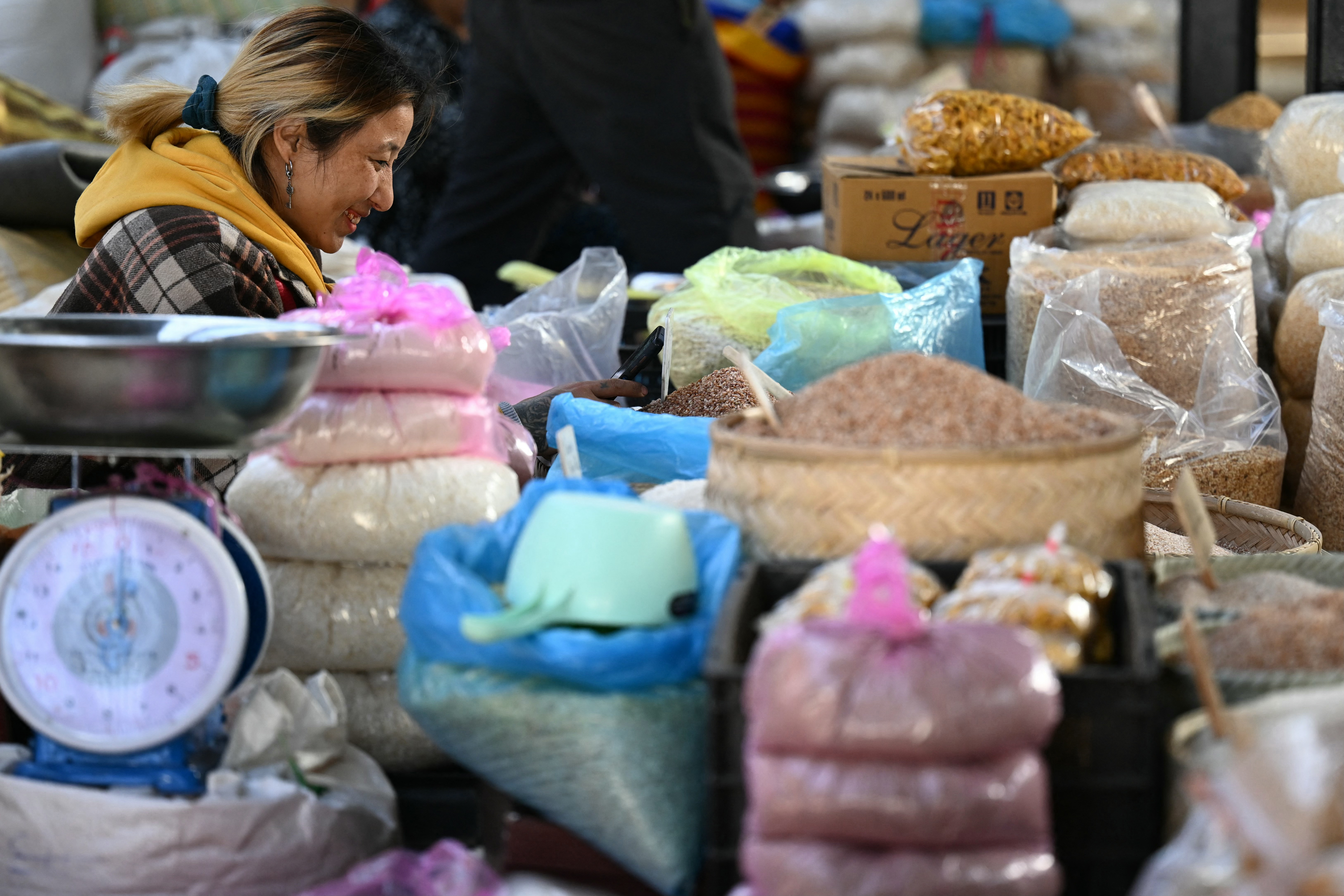 A vendor waits for customers in a stall at a market in Thimphu