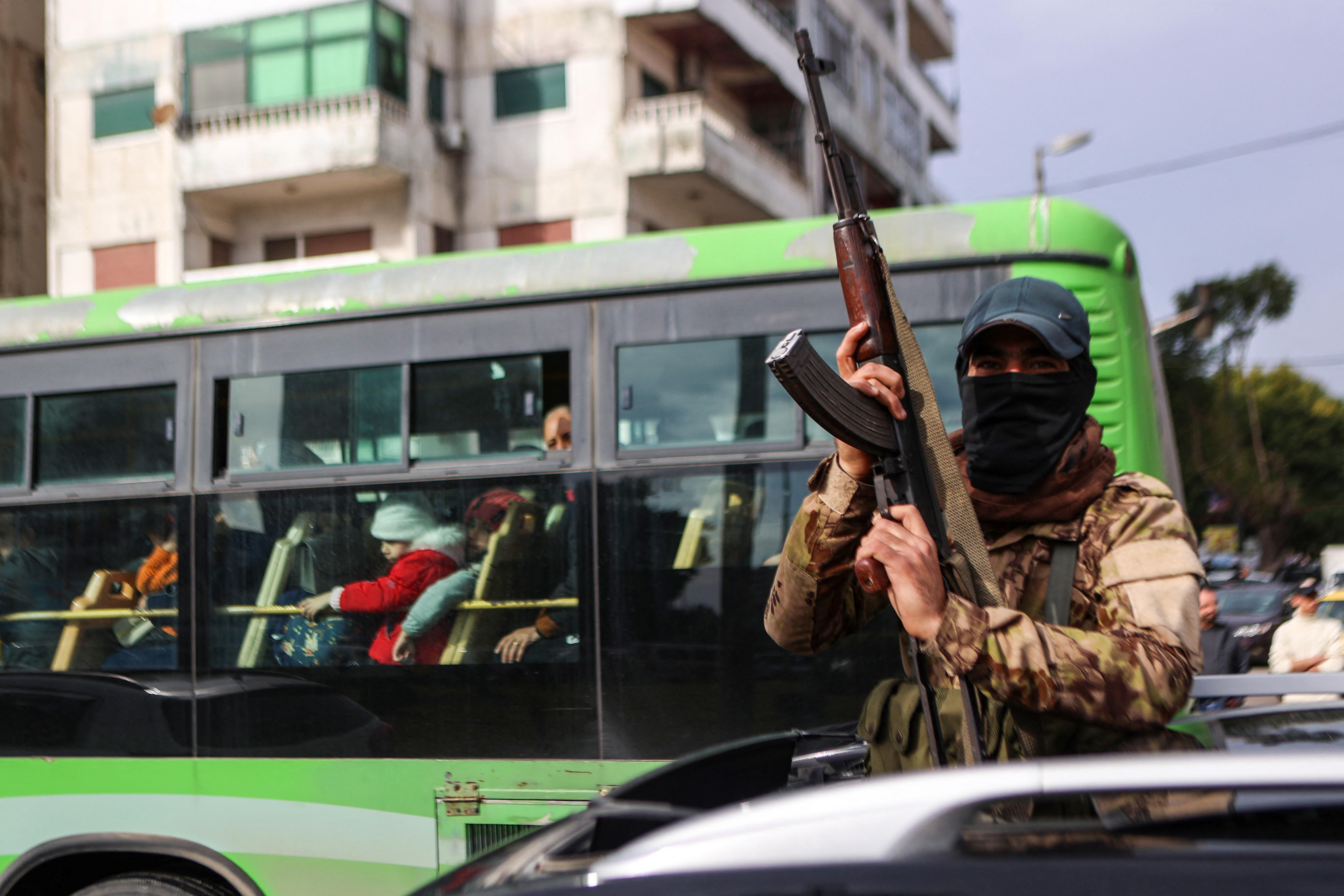 A fighter gestures with his gun.