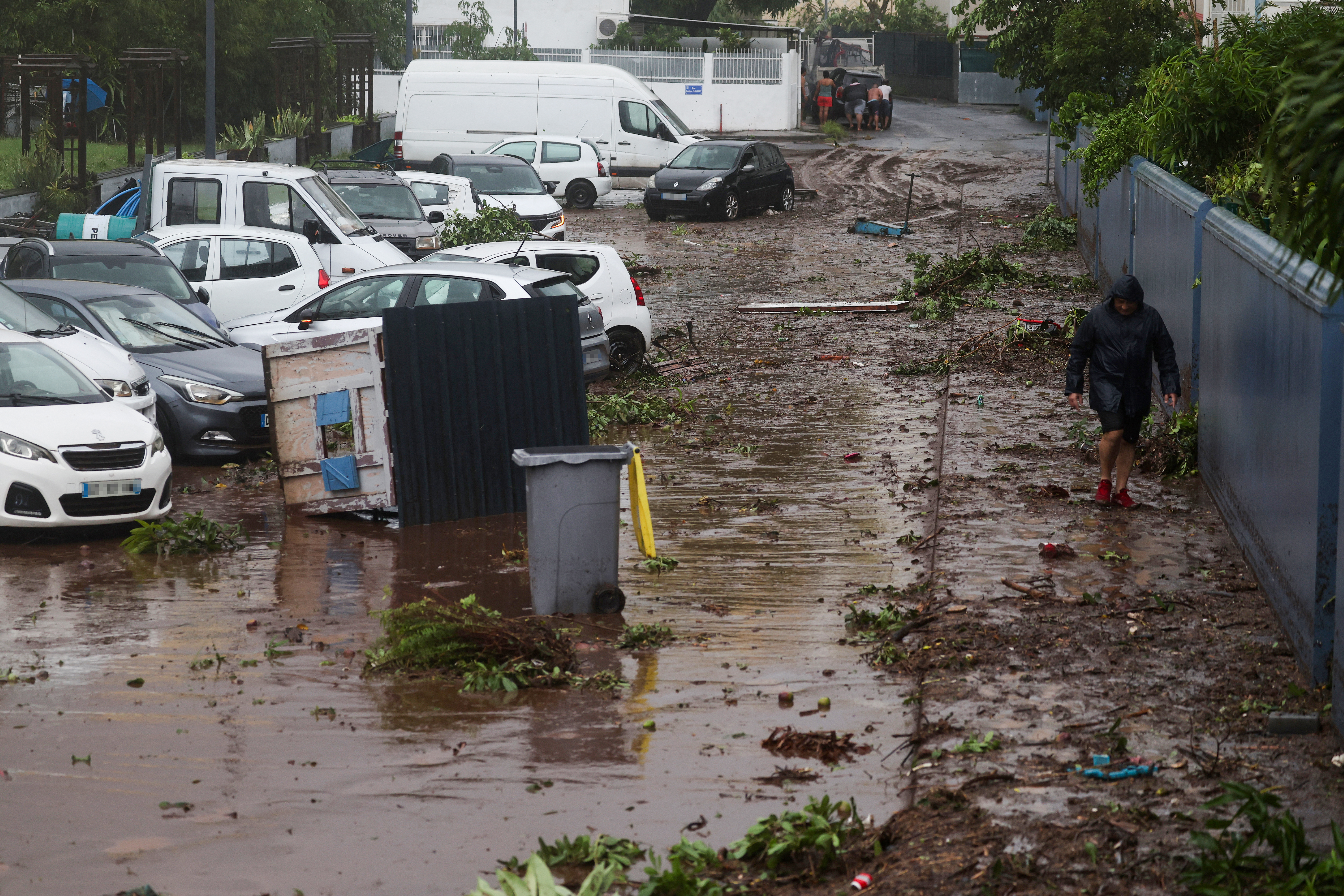 A man walks in a damaged street following a cyclone.