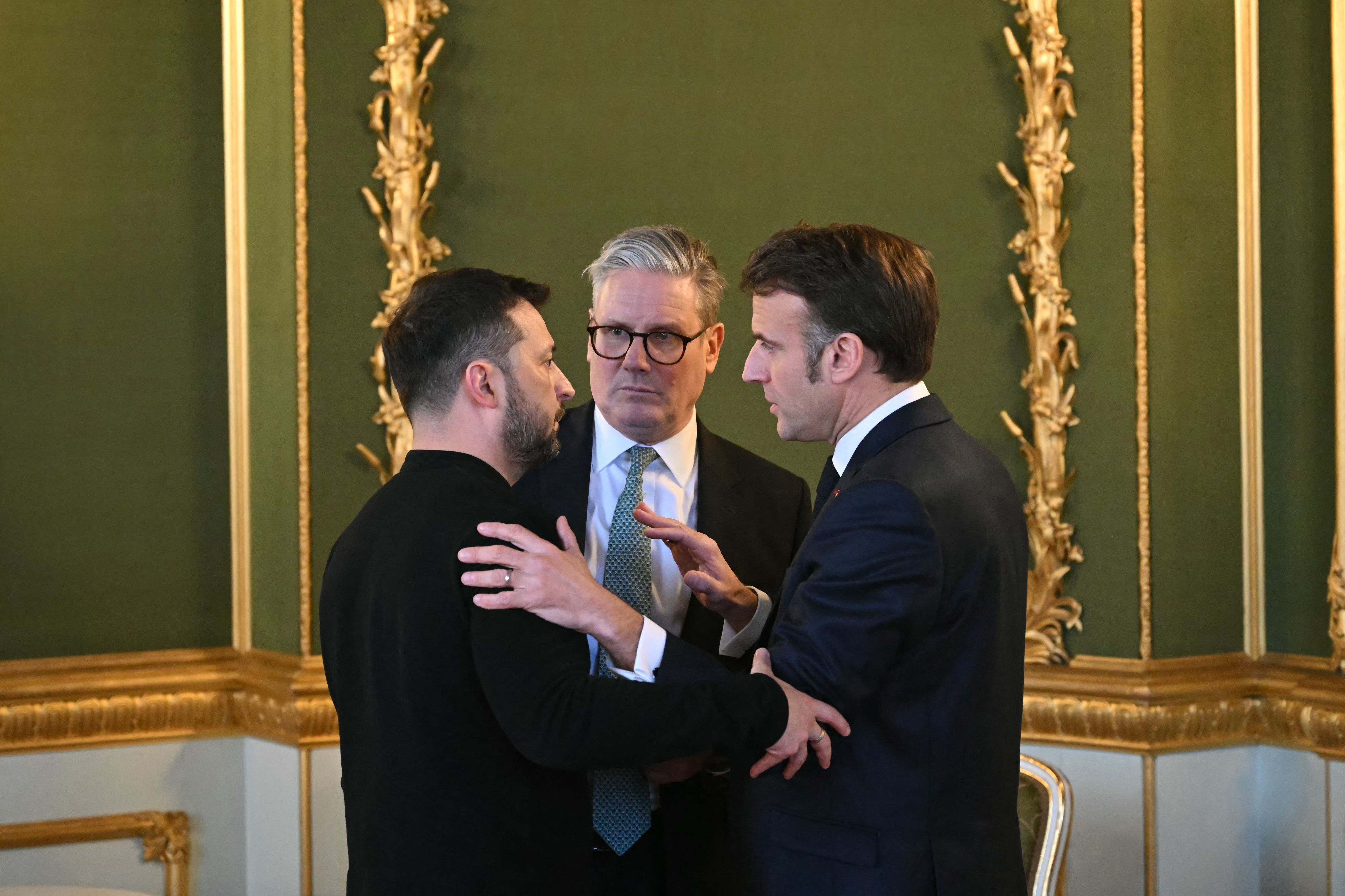 Ukraine's President Volodymyr Zelenskyy, British Prime Minister Keir Starmer and France's President Emmanuel Macron embrace after holding a meeting.