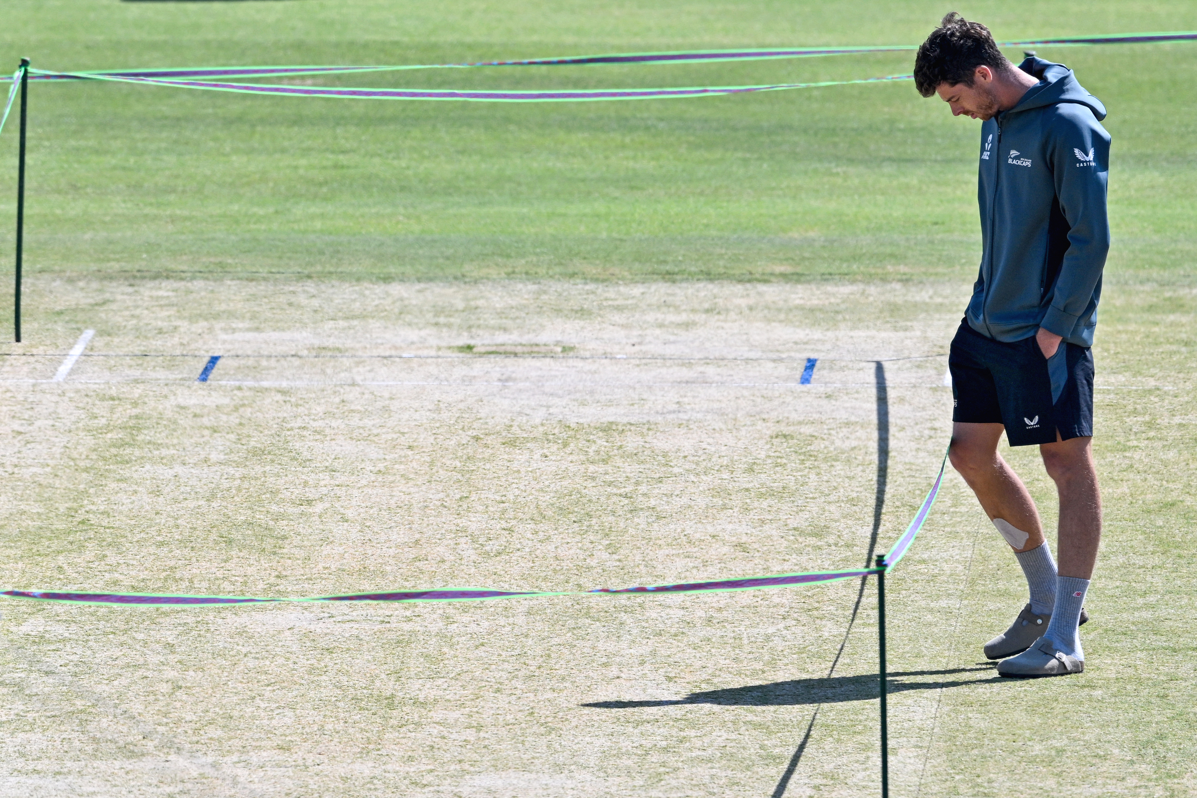 New Zealand's captain Mitchell Santner inspects pitch during a practice session on the eve of their ICC Champions Trophy one-day international (ODI) cricket semi-final match against South Africa at the Gaddafi Stadium in Lahore on March 4, 2025. (Photo by Asif HASSAN / AFP)