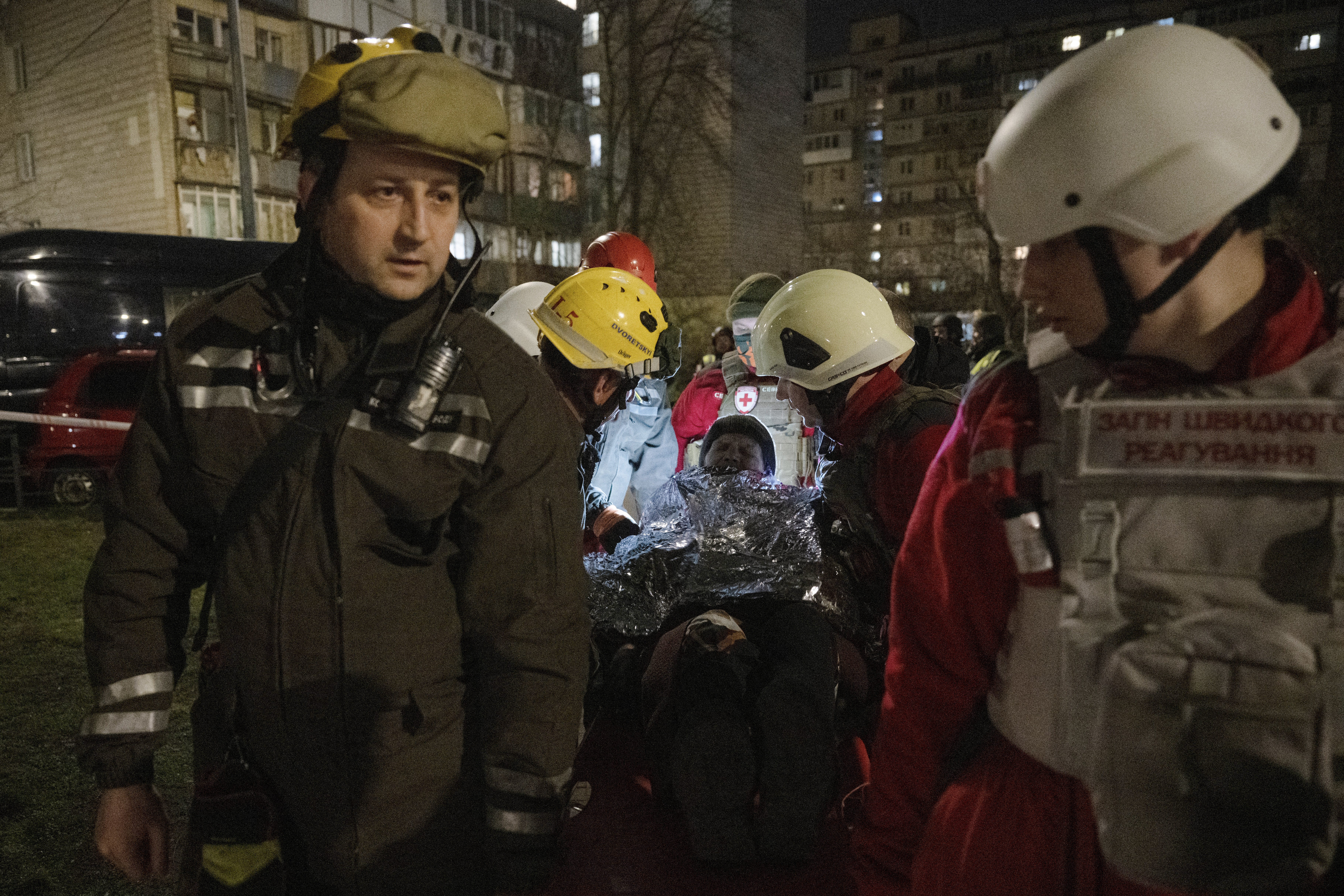 Rescuers and paramedics evacuate an elderly woman near a damaged residential building following a drone attack in Kyiv on March 23, 2025, amid the Russian invasion of Ukraine. (Photo by Genya SAVILOV / AFP)