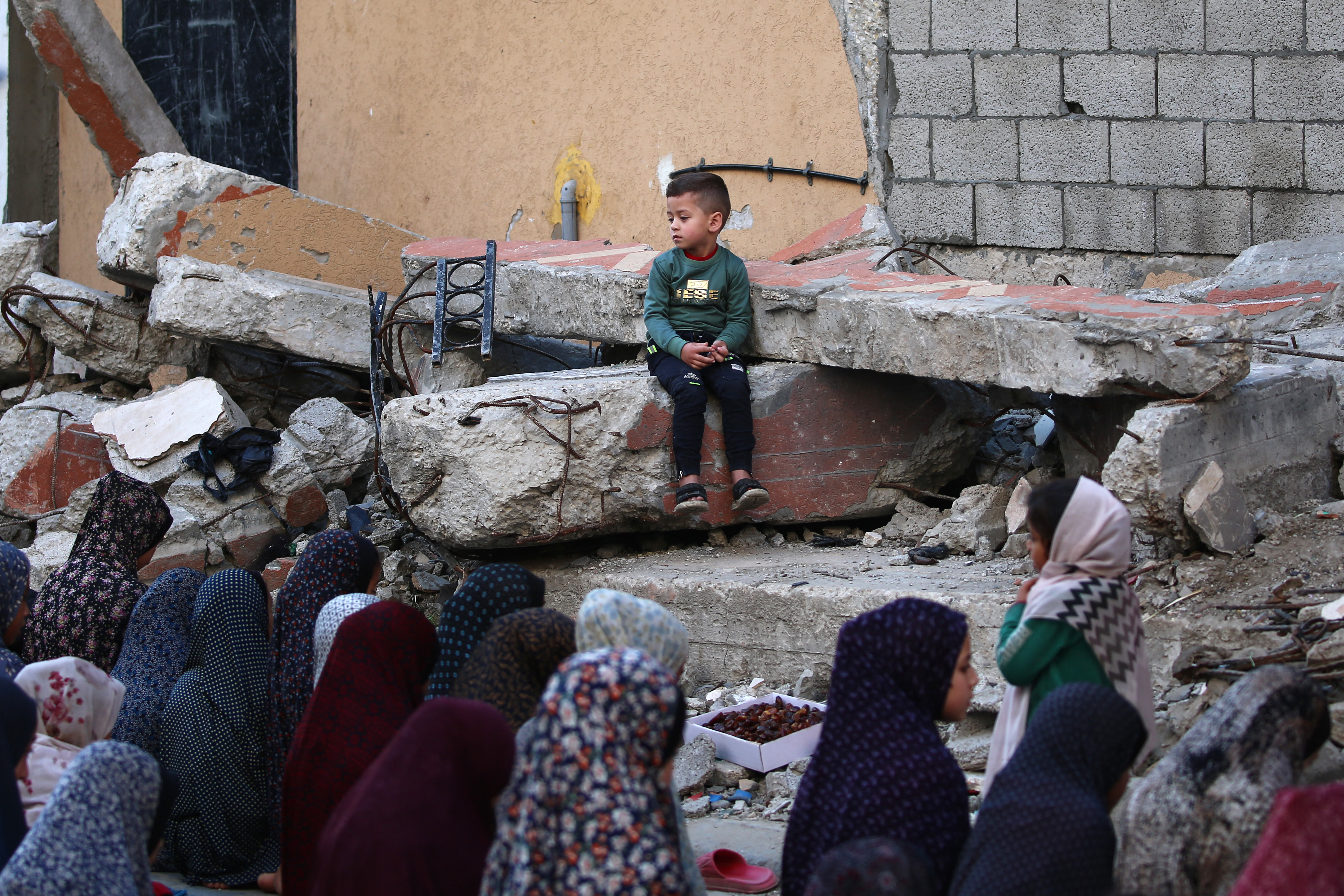 Palestinians visit the grave of a relative after Eid al-Fitr prayers, which marks the end of the holy fasting month of Ramadan, in the Nuseirat camp for Palestinian refugees