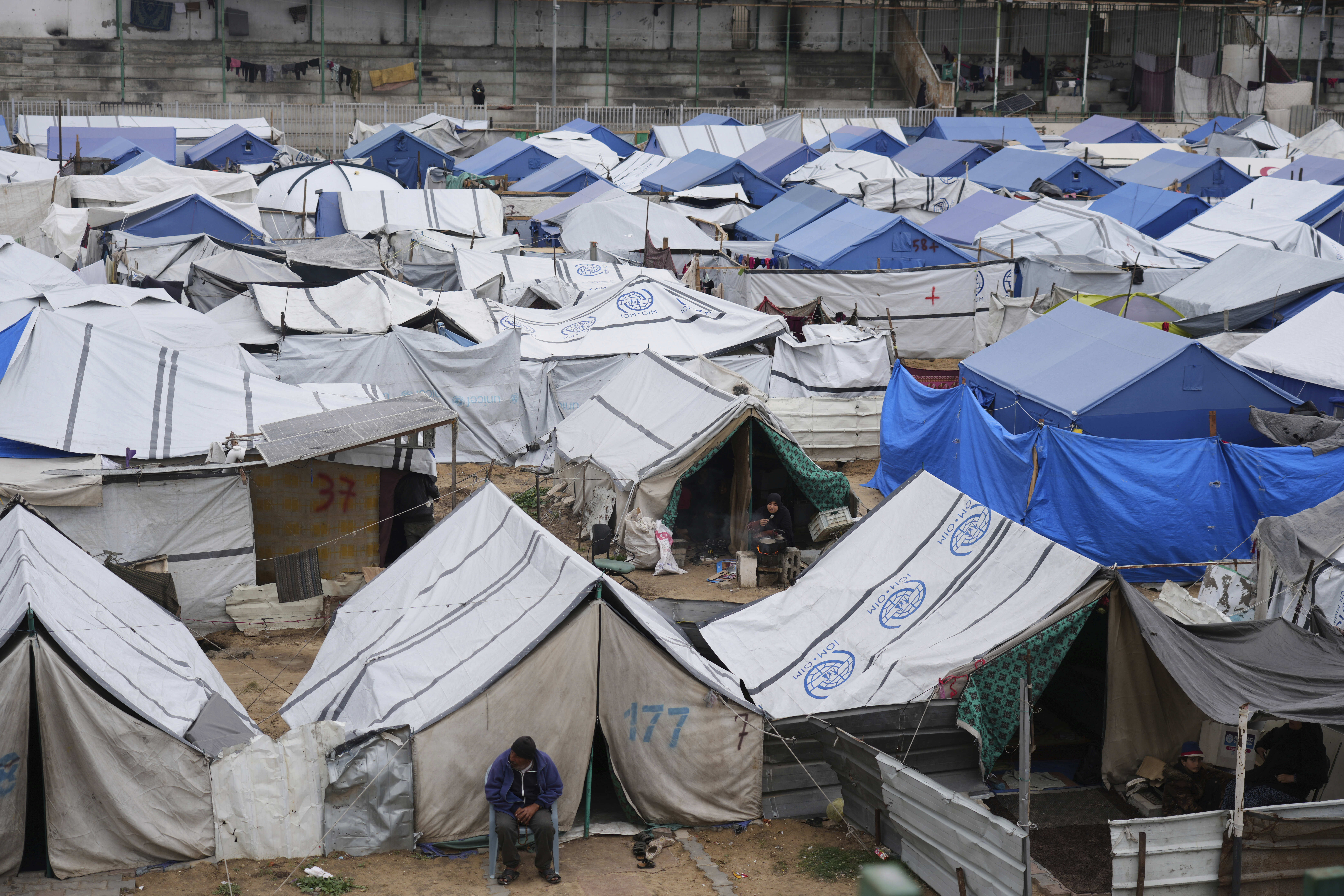 Palestinians displaced by the Israeli air and ground offensive on the Gaza Strip sit in a makeshift tent camp in central Gaza Strip, Friday, March 21, 2025. [Jehad Alshrafi/AP]