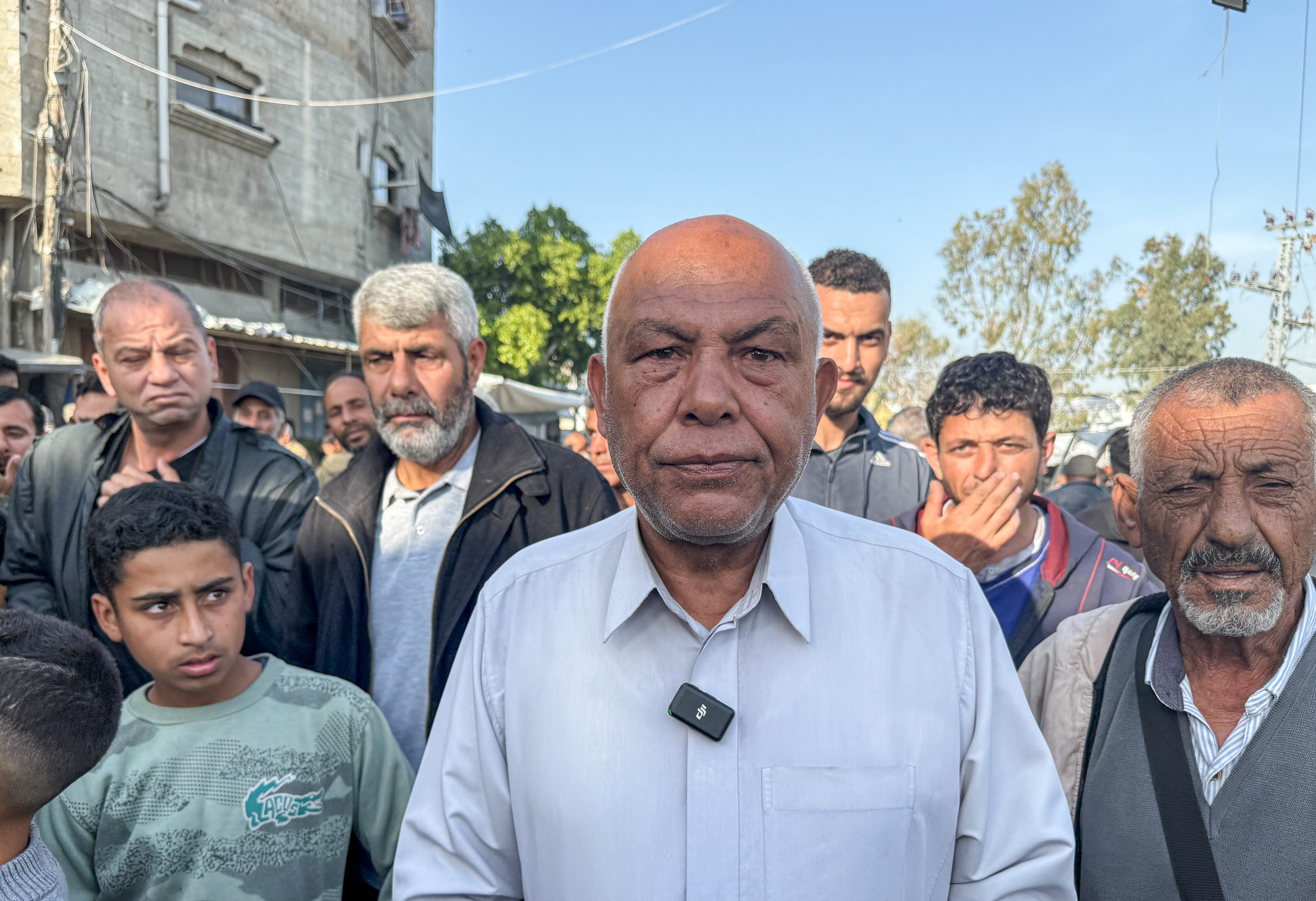A bald man in a tidy shirt looks straight at the camera.