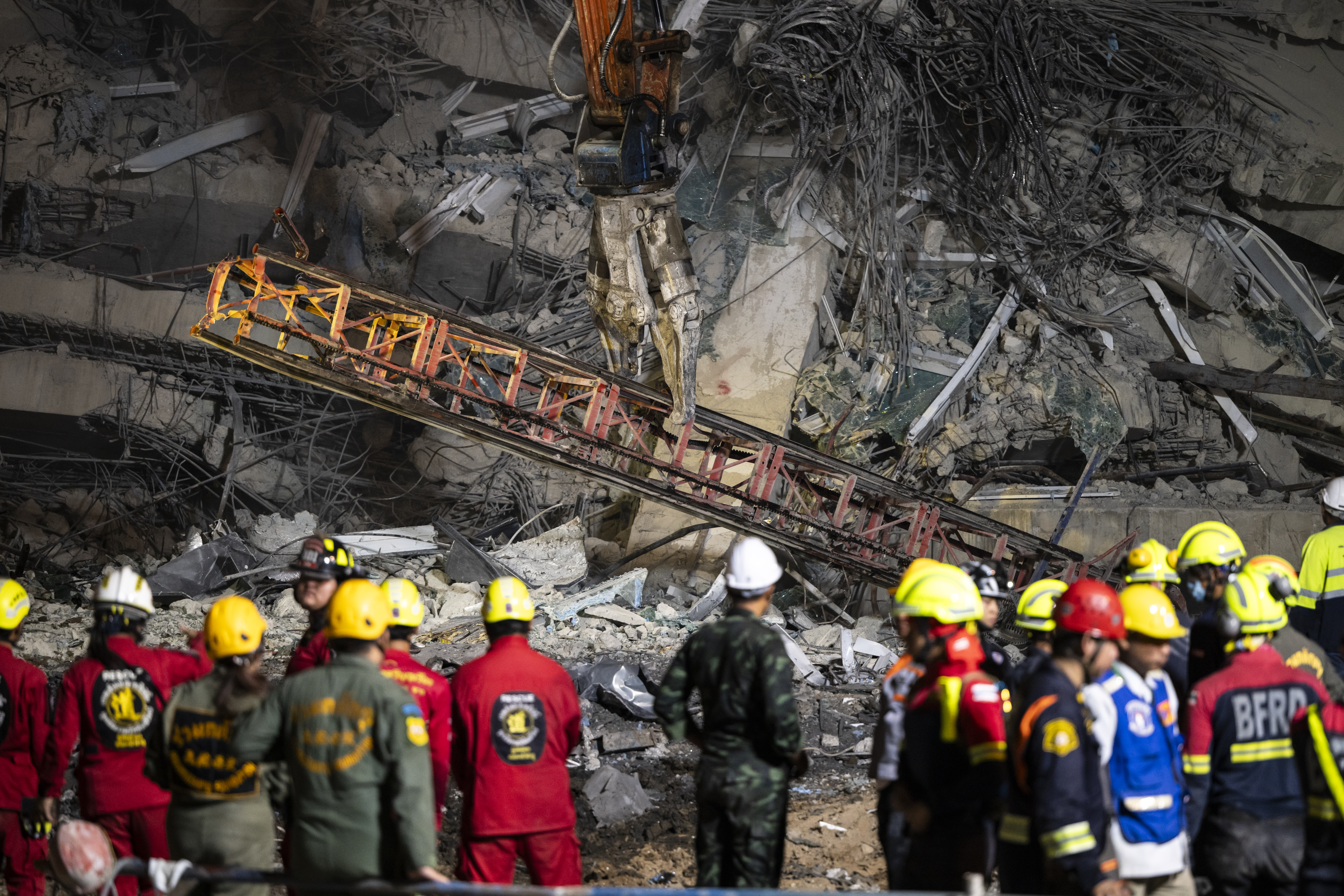 BANGKOK, THAILAND - MARCH 30: A wreckage of a crane is seen being removed by heavy machinery during a search and rescue operation at a collapsed under-construction skyscraper on March 30, 2025 in Bangkok, Thailand. In the aftermath of the 7.3 magnitude earthquake that struck Myanmar, Bangkok finds itself in an unprecedented state of paralysis in Friday evening. The tremors, felt strongly in the Thai capital, transformed the usually vibrant city into a maze of motionless vehicles and anxious faces. As rescue efforts continue at a collapsed building site, the city's arteries remain clogged, with millions of residents caught between the urge to flee and the impossibility of movement, painting a picture of a metropolis frozen in time by nature's sudden fury. (Photo by Sirachai Arunrugstichai/Getty Images)