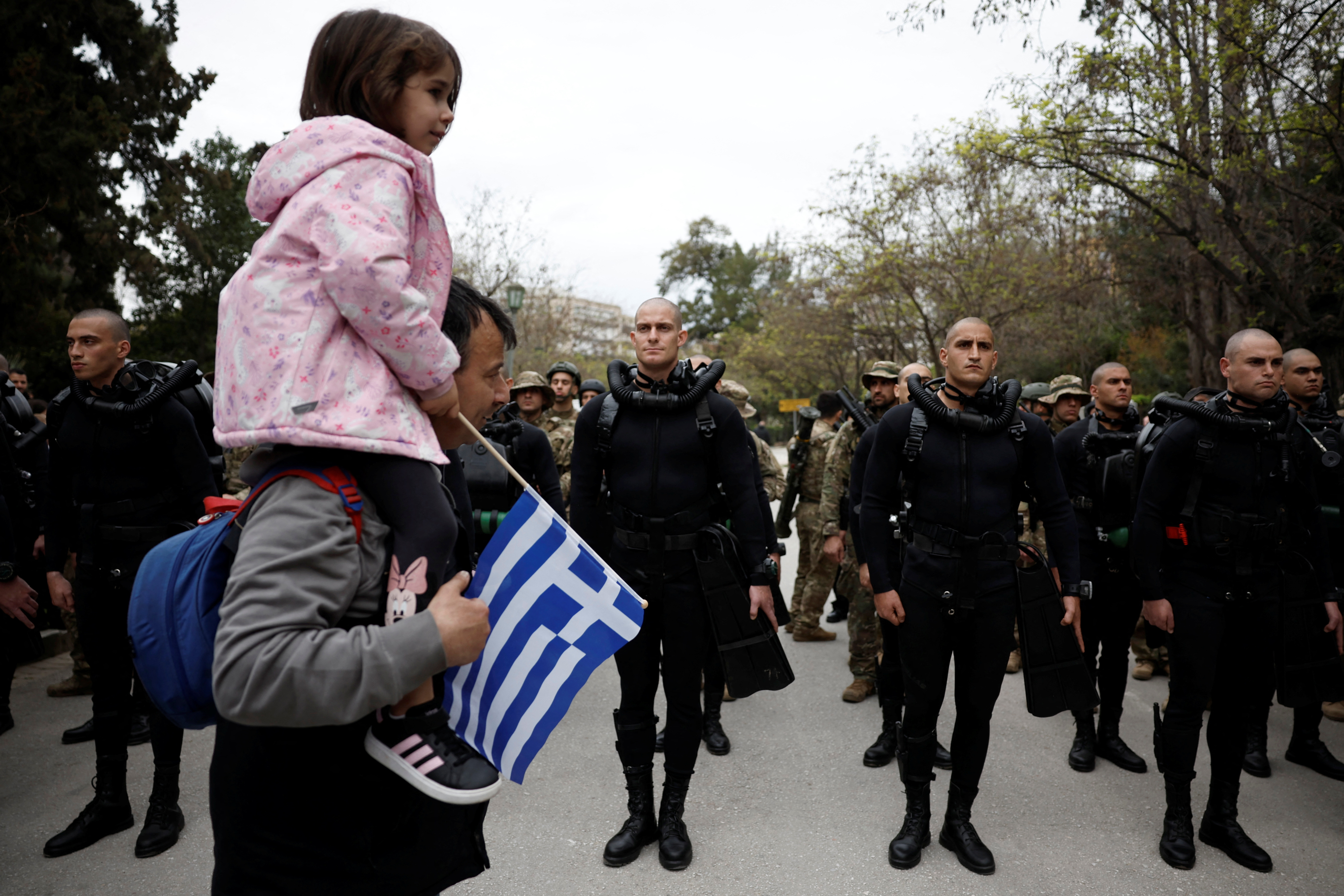 People walk in front of Hellenic Army personnel of the Underwater Demolition Command before a military parade marking Greece's Independence Day, in Athens, Greece, March 25, 2025. REUTERS/Louiza Vradi