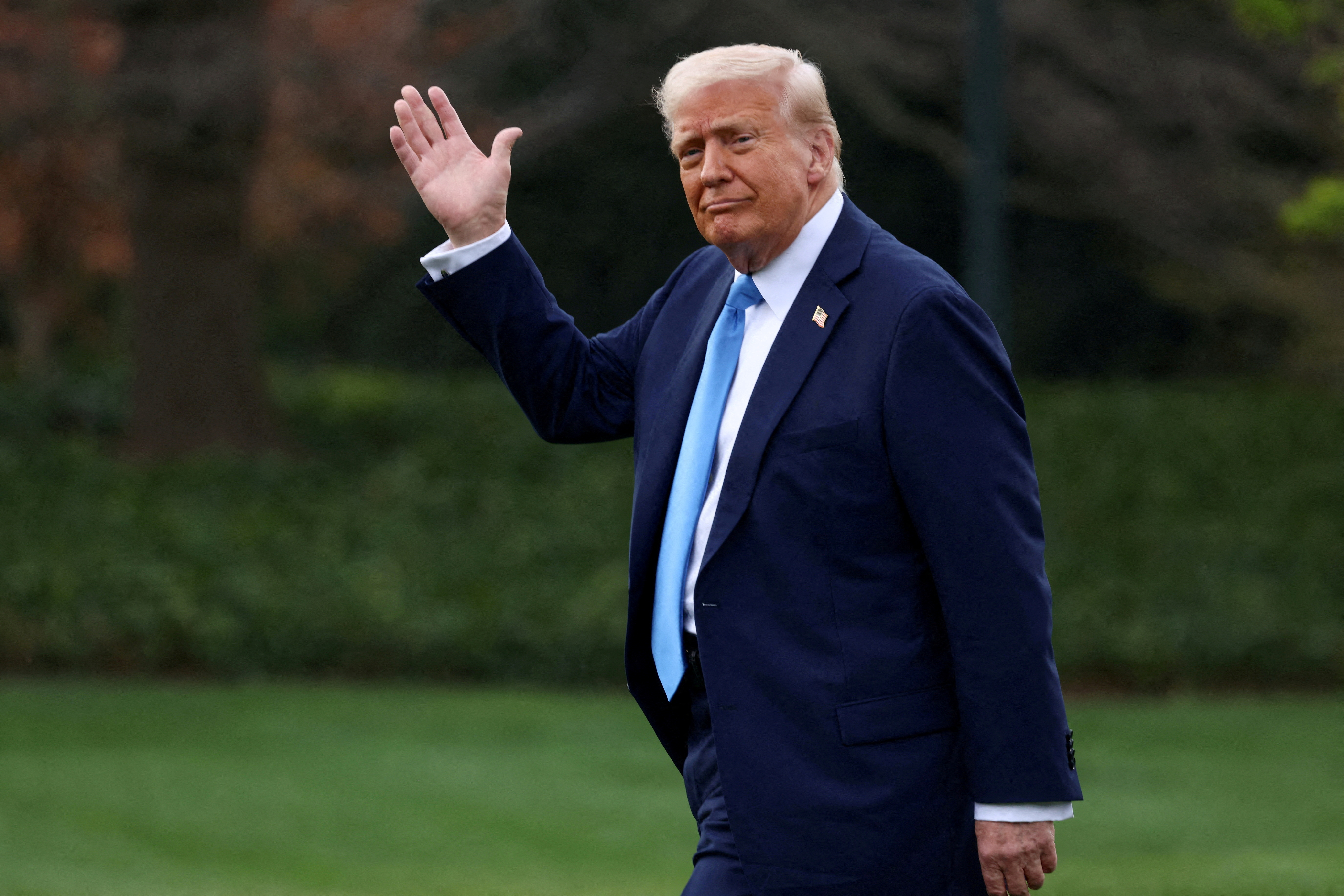 FILE PHOTO: U.S. President Donald Trump waves as he walks before departing for Florida from the South Lawn at the White House in Washington, D.C., U.S., March 28, 2025. REUTERS/Evelyn Hockstein/File Photo