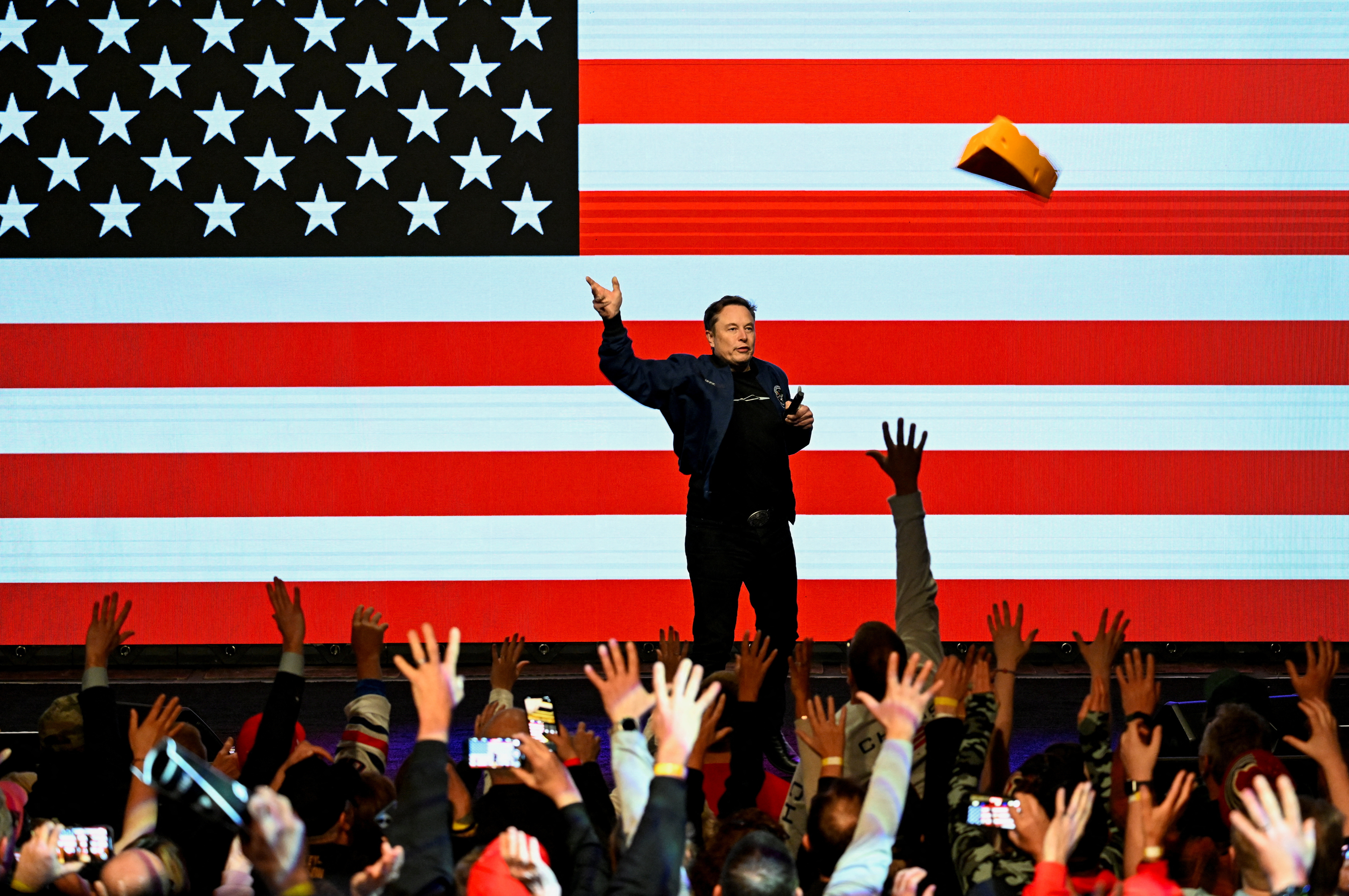 U.S. President Donald Trump's adviser Elon Musk throws an autographed cheese hat as he holds a rally in support of a conservative state Supreme Court candidate of an April 1 election in Green Bay, Wisconsin, U.S. March 30, 2025. REUTERS/Vincent Alban