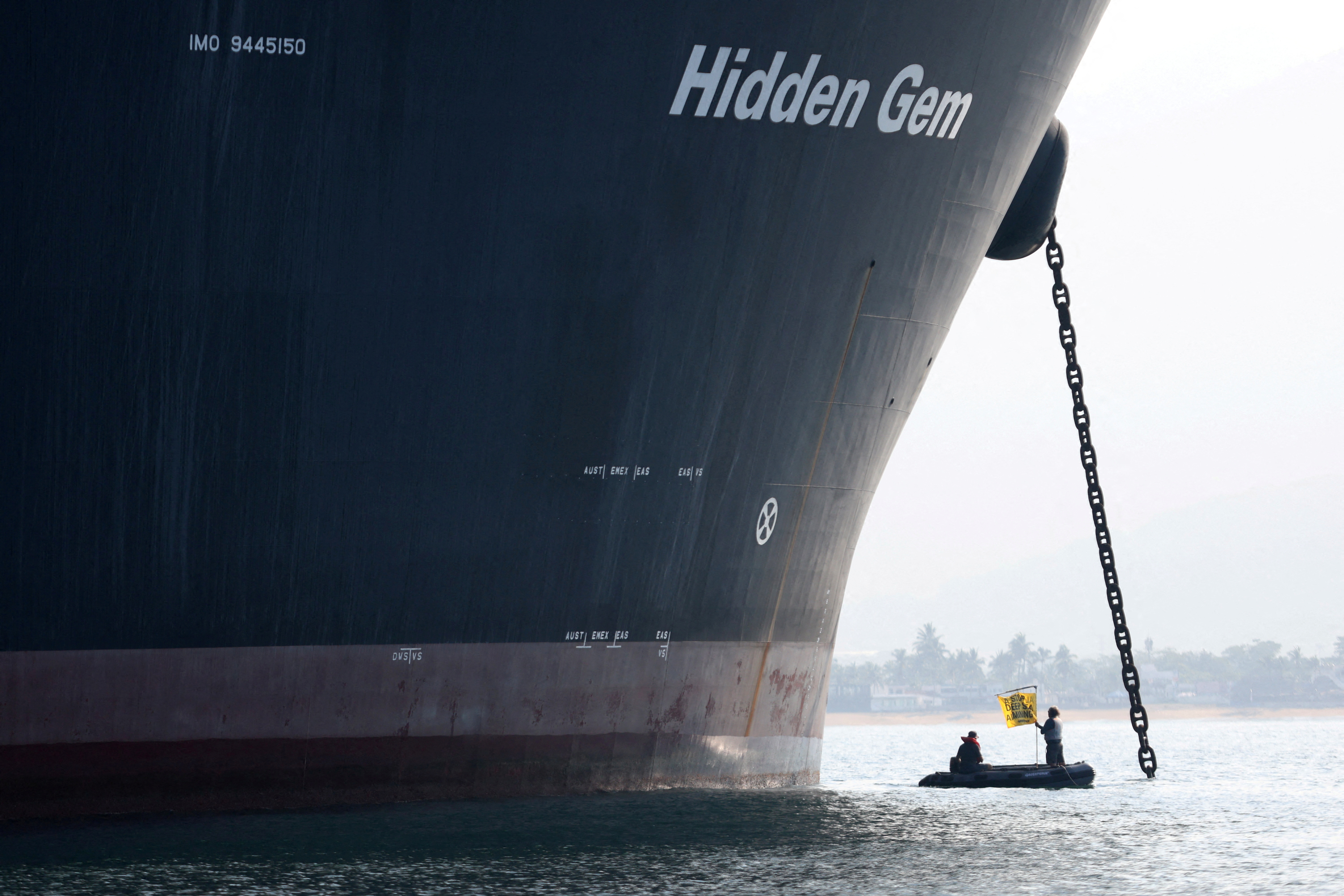 FILE PHOTO: A Greenpeace activist holds a banner during a protest near the deep sea mining vessel Hidden Gem, commissioned by Canadian miner The Metals Company, in the Mexican Pacific port of Manzanillo, in Manzanillo, Mexico September 27, 2023. Gustavo Graf/Greenpeace Mexico/Handout via REUTERS THIS IMAGE HAS BEEN SUPPLIED BY A THIRD PARTY./File Photo