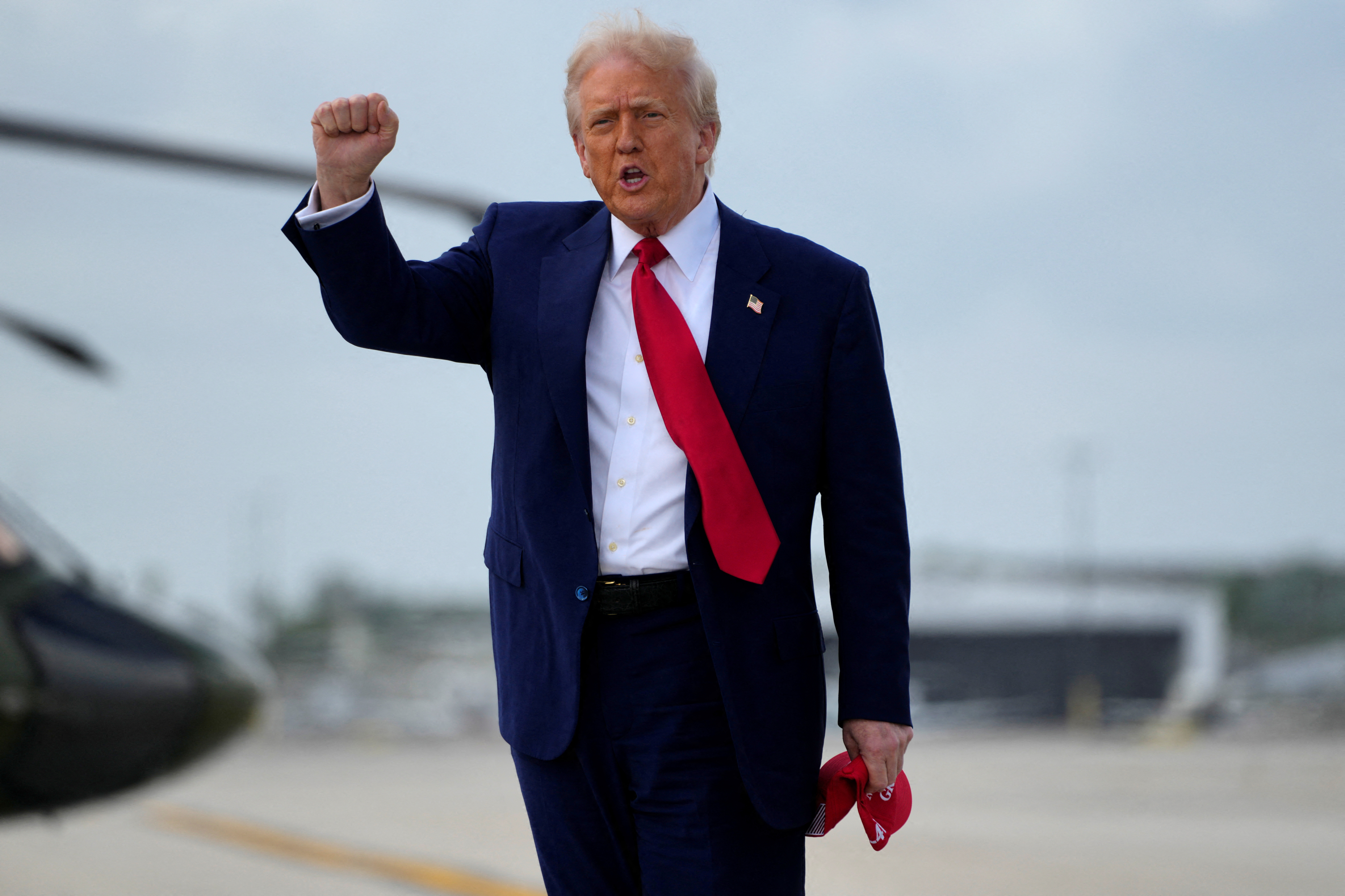 Donald Trump lifts a fist on the tarmac
