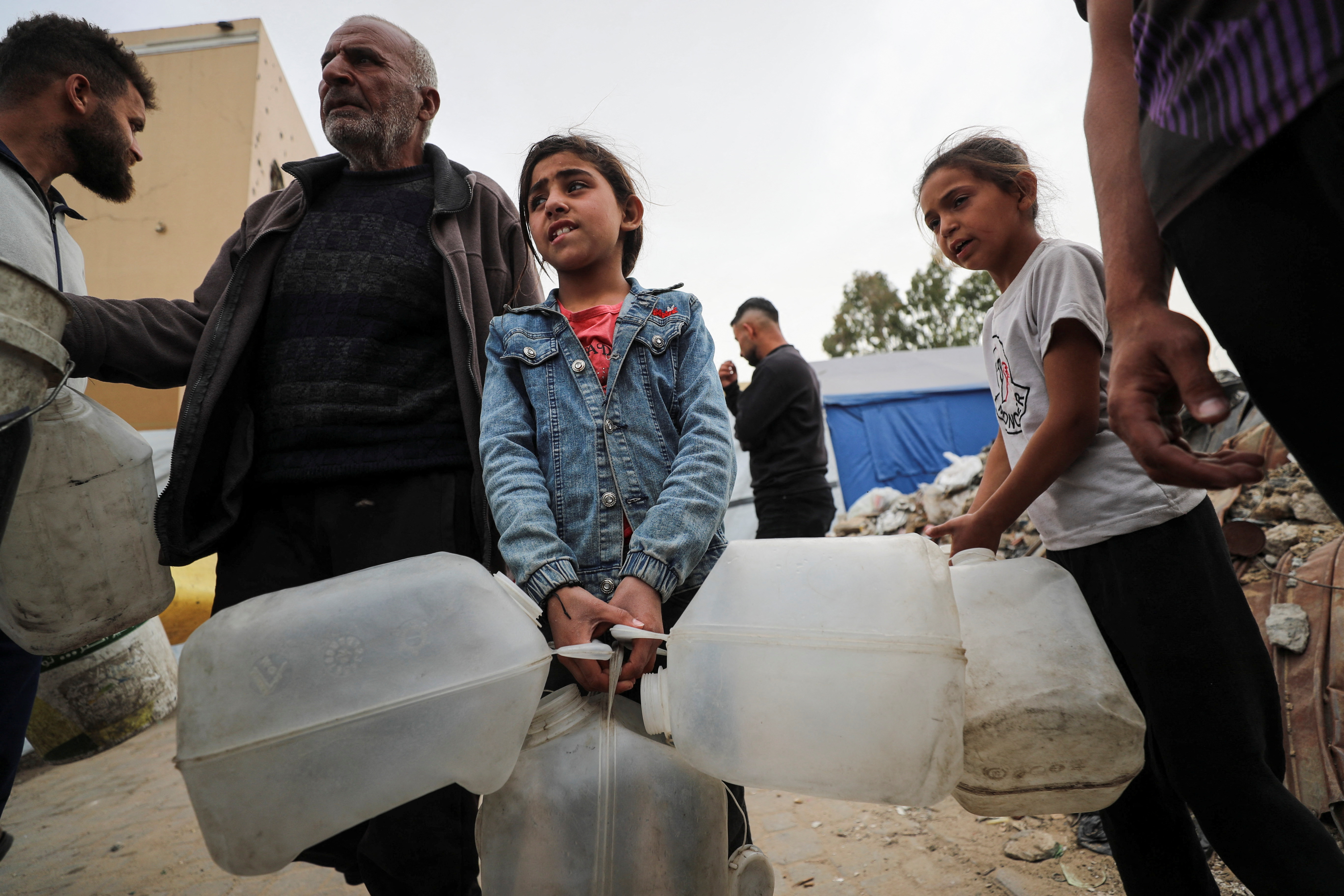 Palestinian children carry containers for water in Gaza City