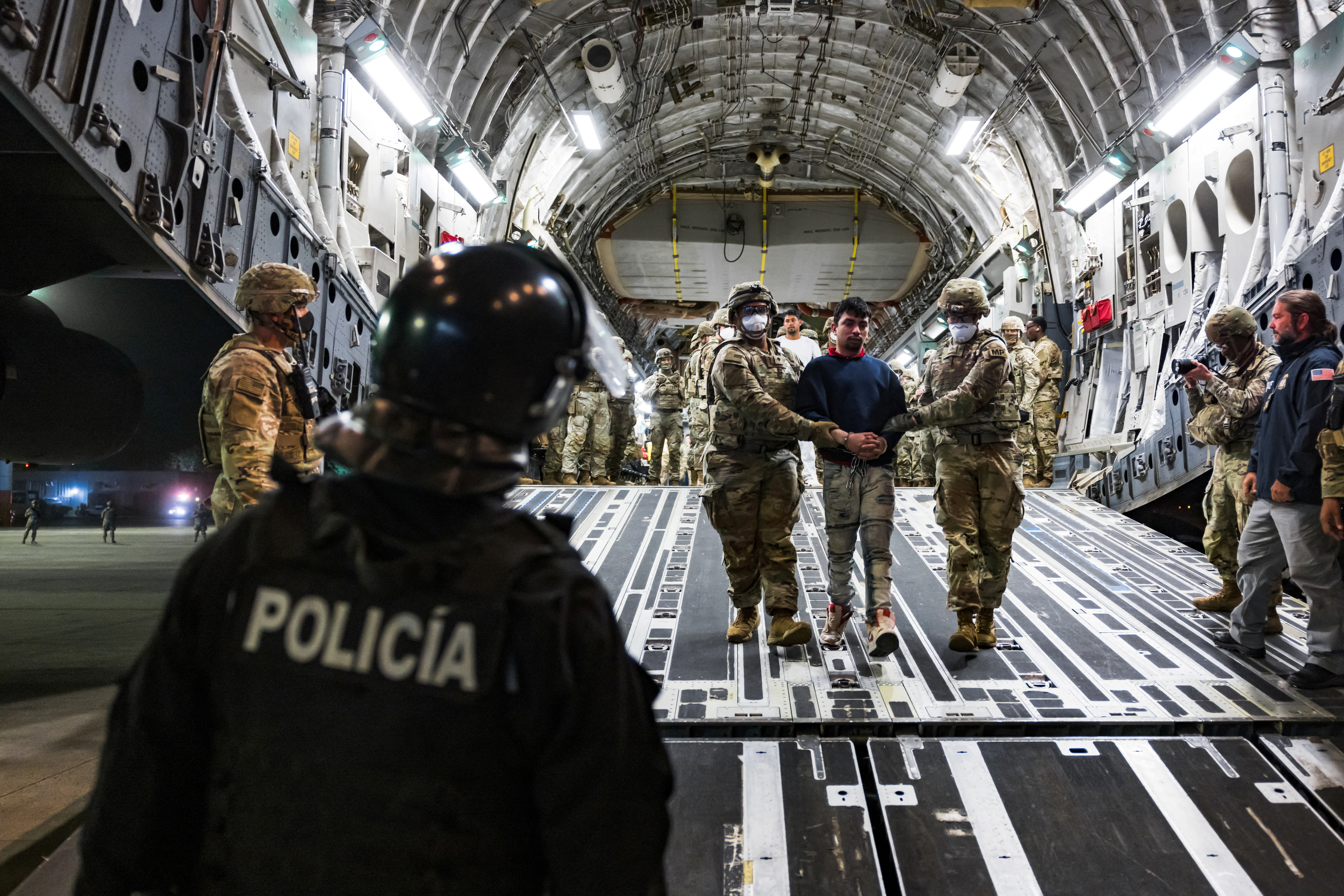 U.S. military personnel escort alleged members of the Venezuelan gang Tren de Aragua and the MS-13 gang recently deported by the U.S. government to be imprisoned in the Terrorism Confinement Center (CECOT) prison, at the El Salvador International Airport in San Luis Talpa, El Salvador April 12, 2025. Secretaria de Prensa de la Presidencia/Handout via REUTERS ATTENTION EDITORS-THIS IMAGE HAS BEEN SUPPLIED BY A THIRD PARTY. NO RESALES. NO ARCHIVES