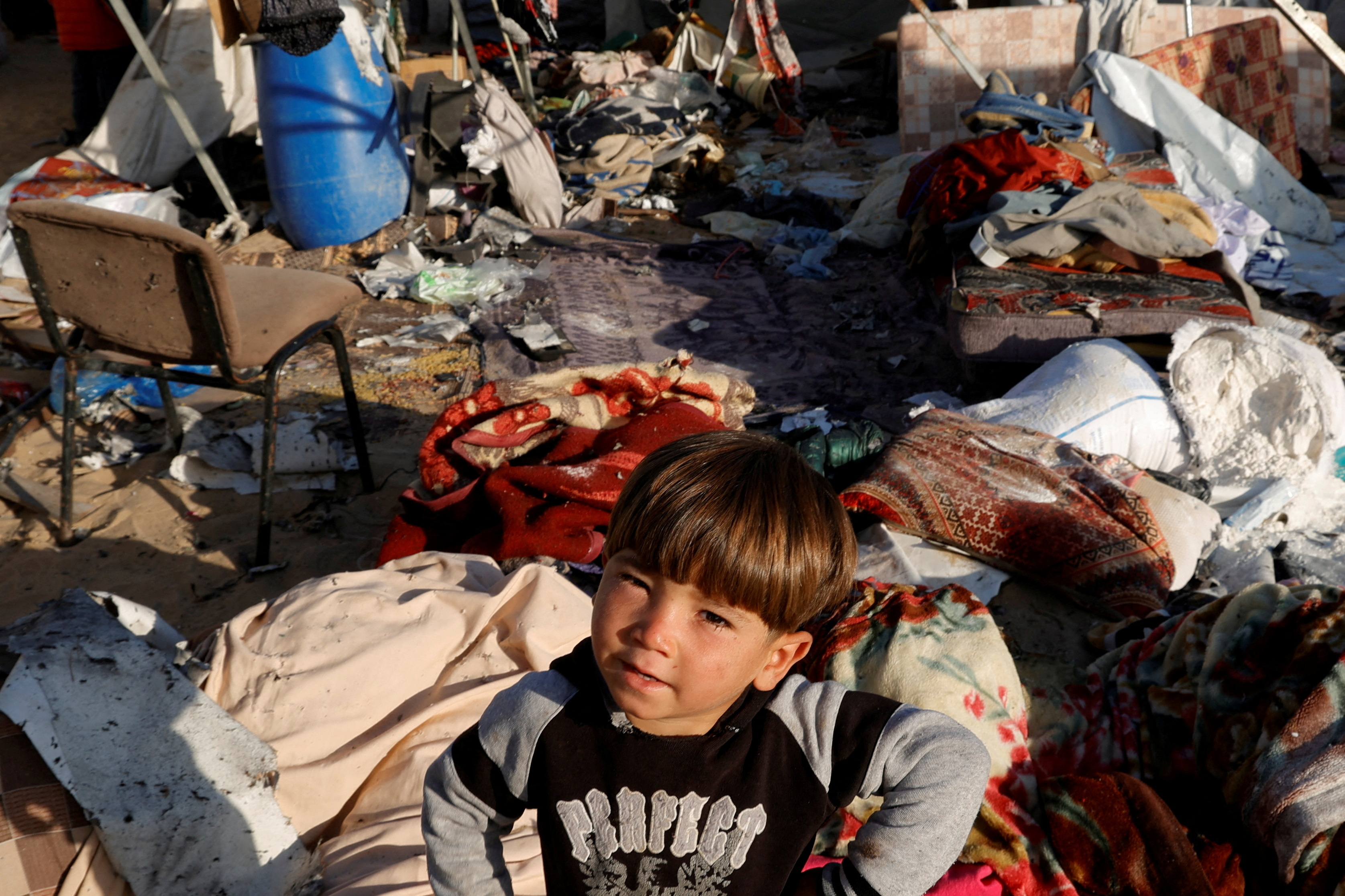 A child looks on as Palestinians inspect the damage at the site of an Israeli strike on a tent sheltering displaced people, in Khan Younis in the southern Gaza Strip April 15, 2025. [Hatem Khaled/Reuters]