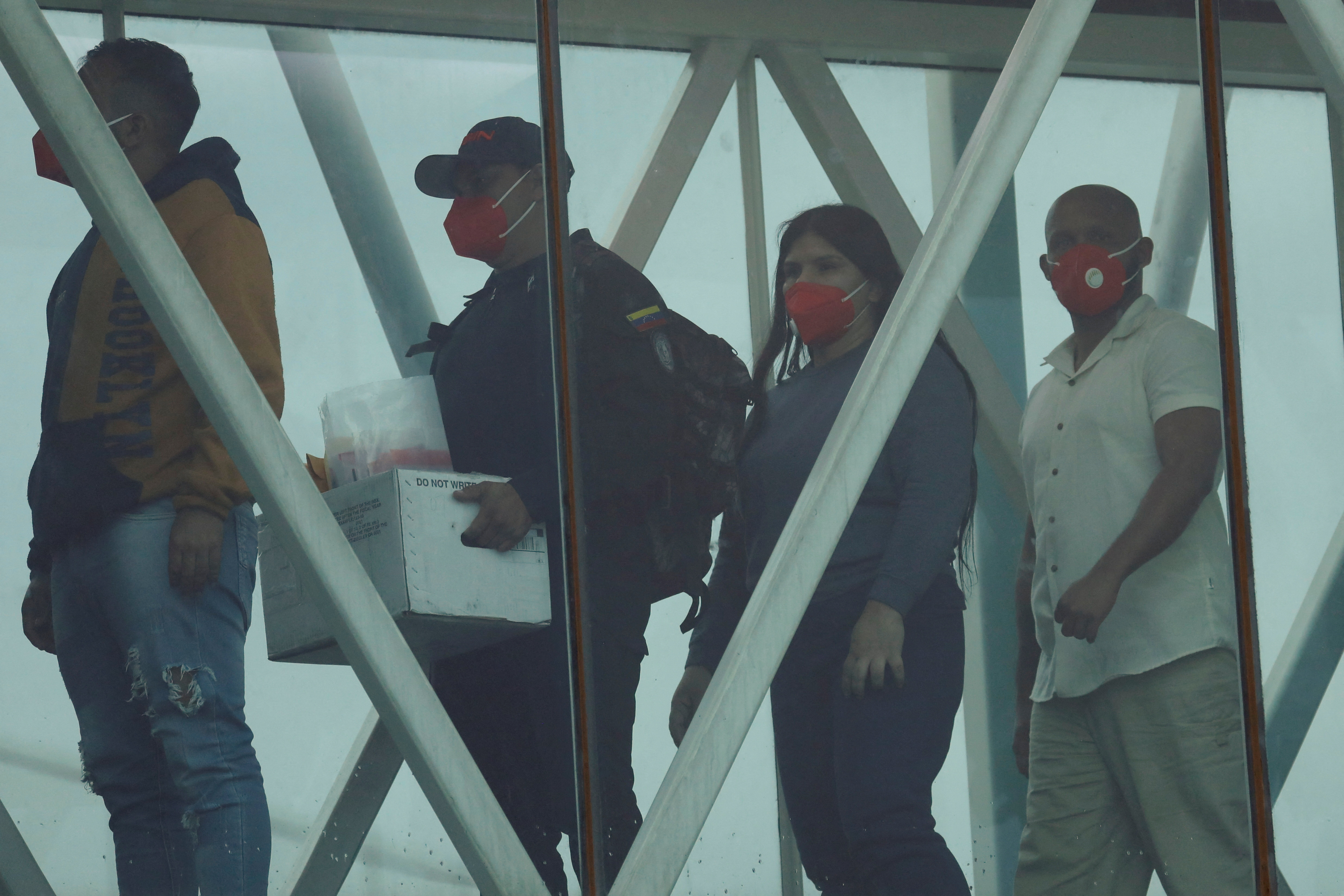 A member of SEBIN (Bolivarian National Intelligence Service) carries a box with the files of the Venezuelan migrants as migrants arrive after being deported from the United States, at the Simon Bolivar International Airport, in Maiquetia, Venezuela April 23, 2025. REUTERS/Leonardo Fernandez Viloria