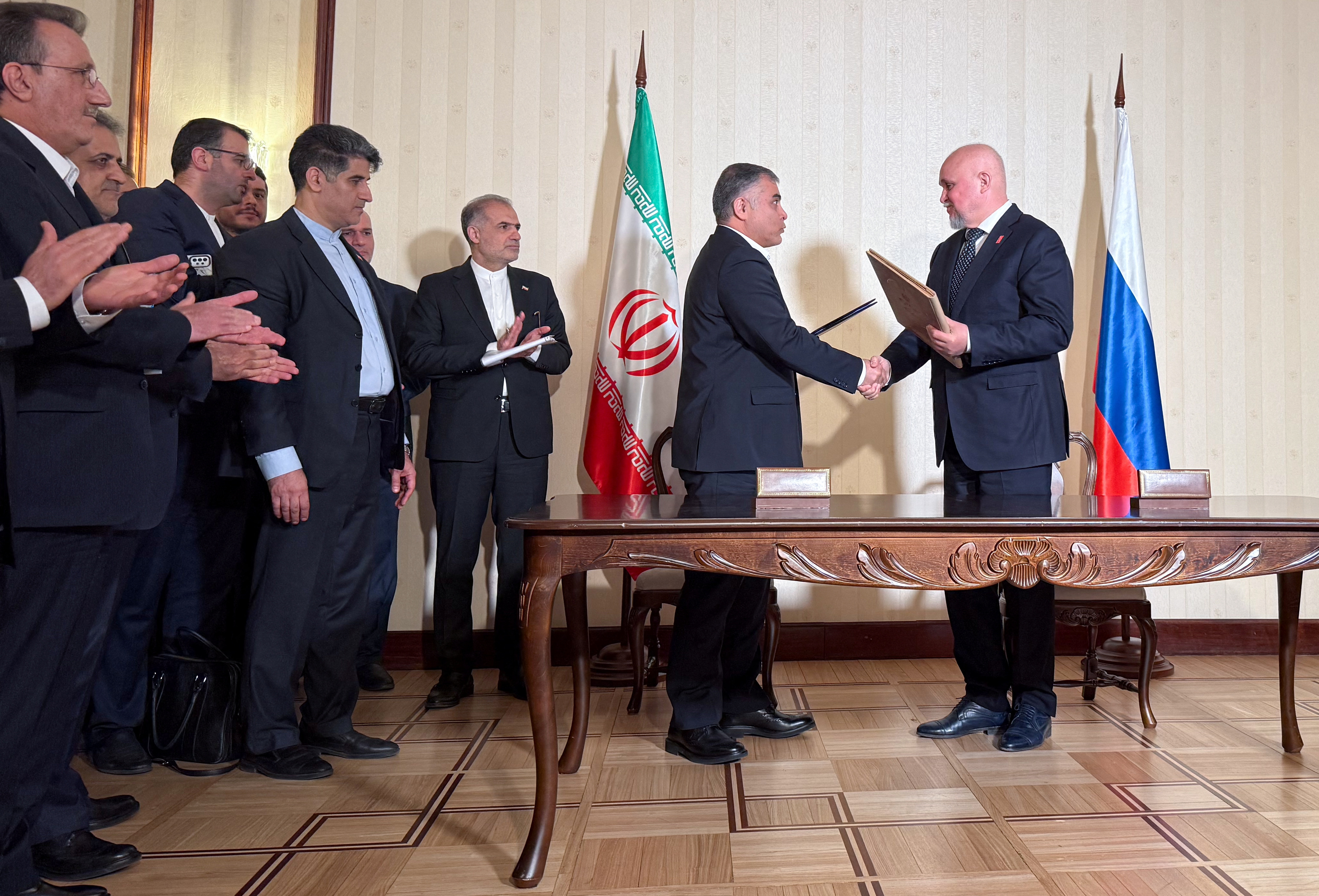 Russian Energy Minister Sergei Tsivilev and Iranian Oil Minister Mohsen Paknejad exchange documents during a signing ceremony in Moscow, Russia, April 25, 2025. REUTERS/Olesya Astakhova